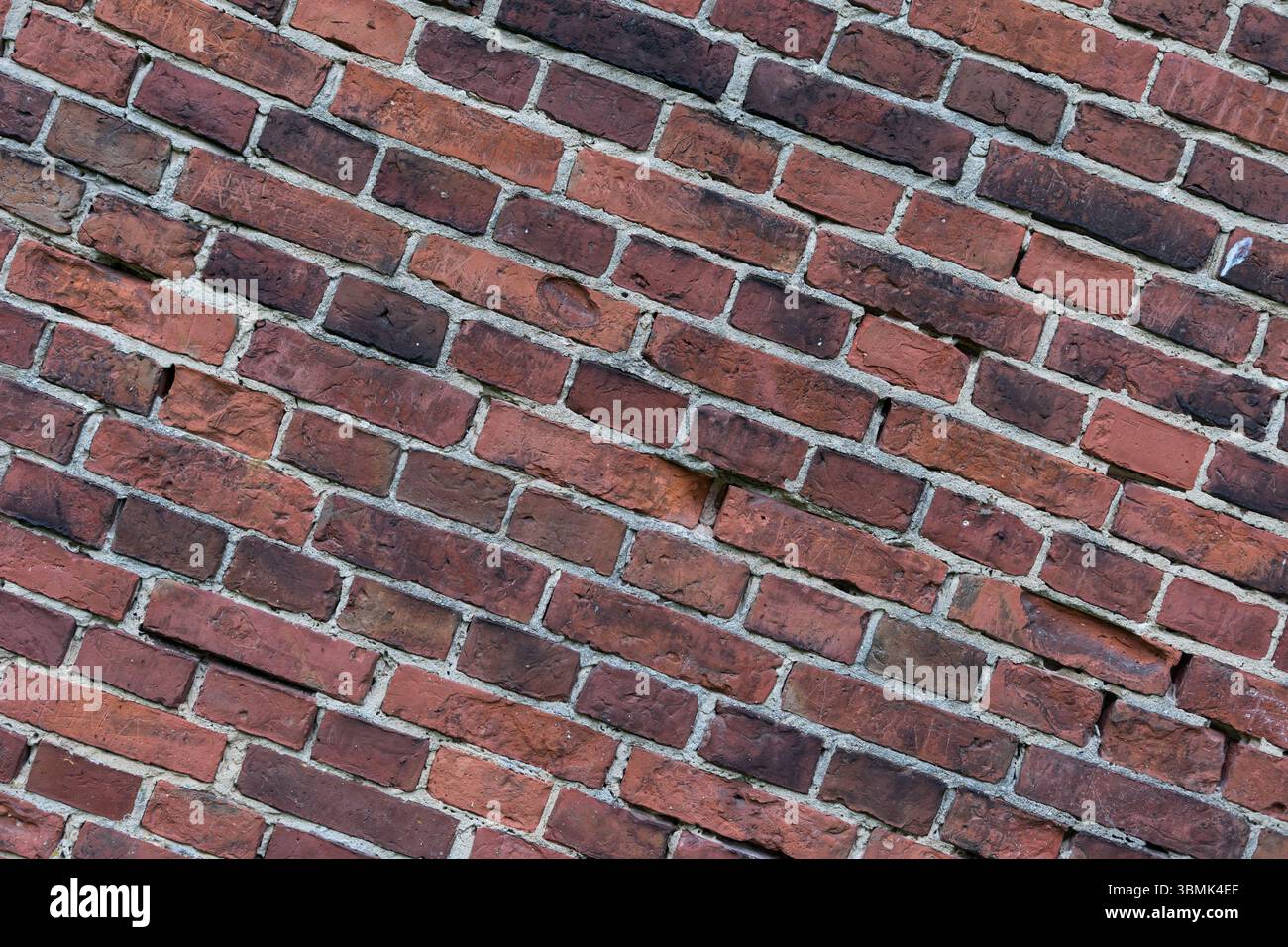 Diagonale Ansicht einer roten Ziegelmauer. Strukturierter architektonischer Hintergrund Stockfoto