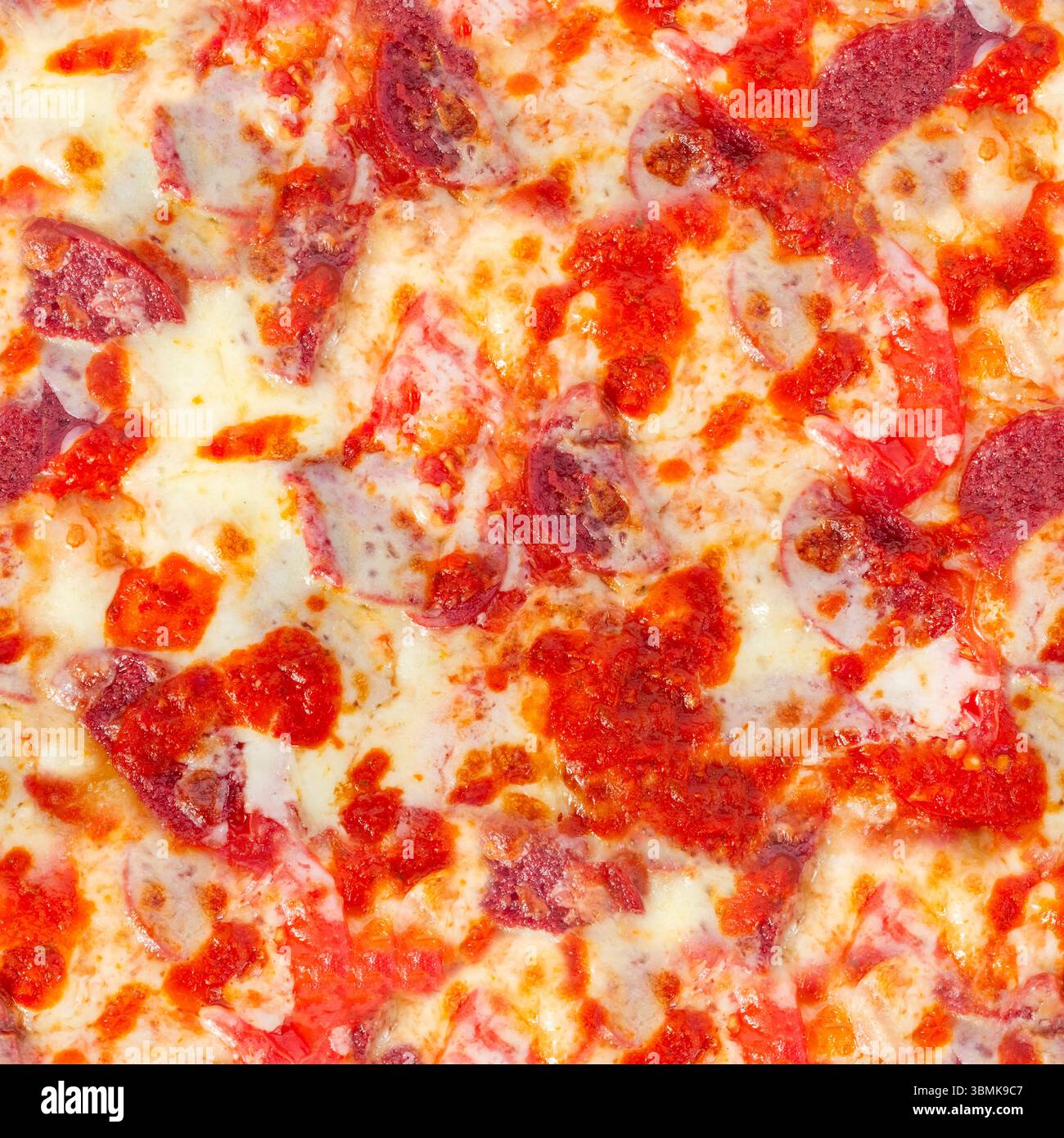 Nahtlose 4K-Fototextur von scharfer Peperoni-Pizza mit Käse und roter Pfefferoberfläche. Stockfoto