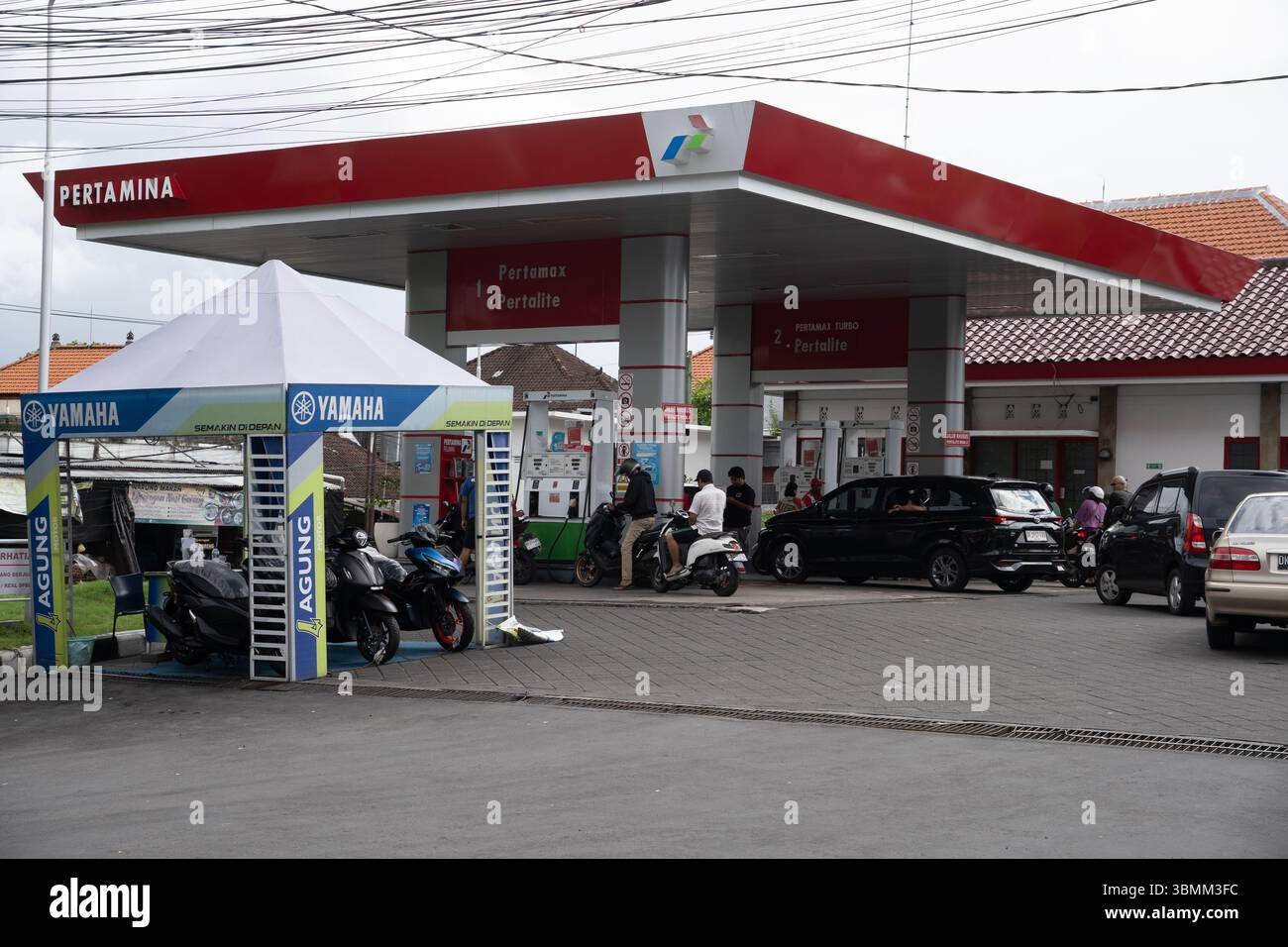 Bali, Indonesien - 29. Dezember 2024: Pertamina Tankstelle. Tankstelle mit Yamaha-Zelt und davor geparkten Motorrädern. Es gibt mehrere Autos an Stockfoto