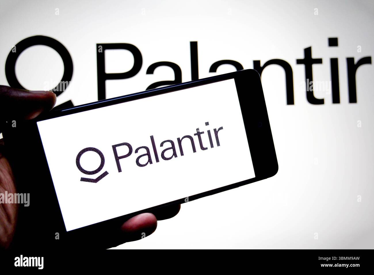 In dieser Abbildung ist ein Palantir-Logo auf einem Smartphone und im Hintergrund zu sehen. Stockfoto