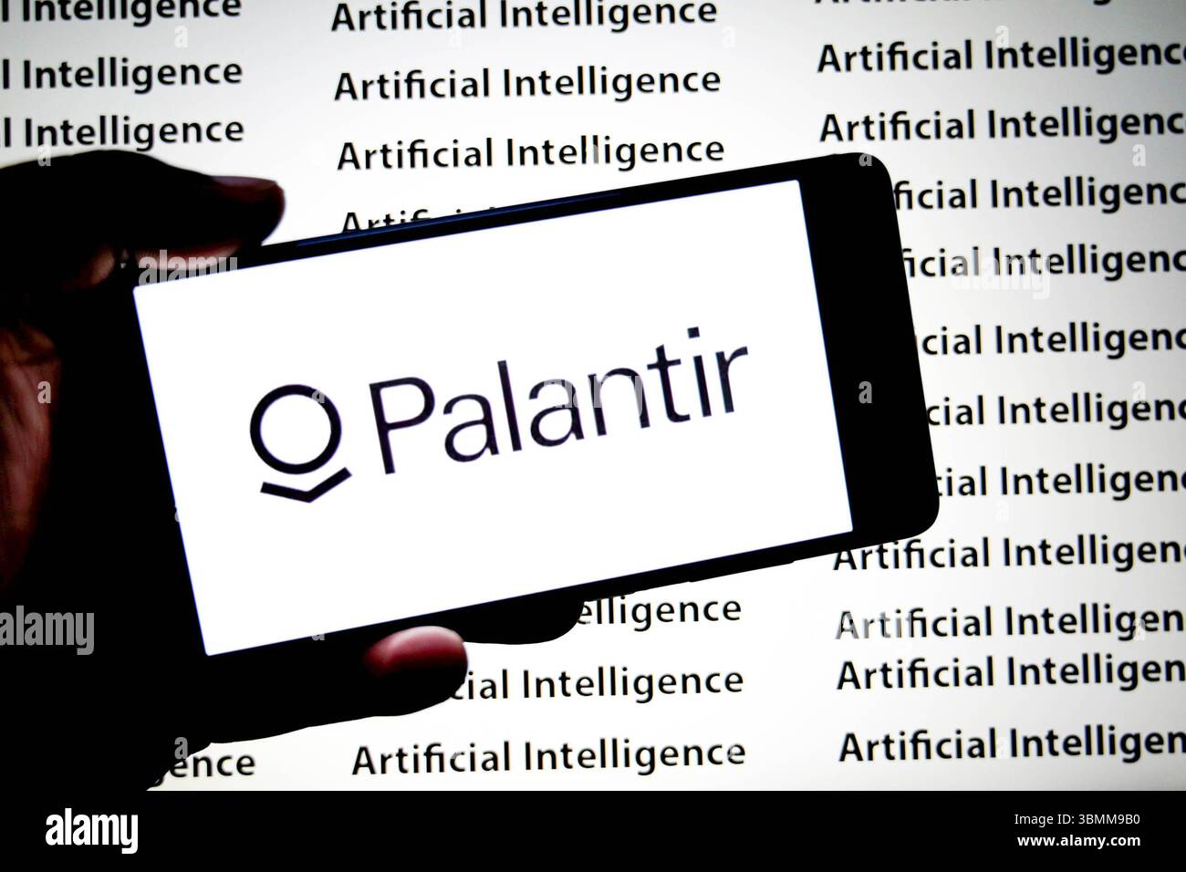In dieser Abbildung ist ein Palantir-Logo auf einem Smartphone mit einer Künstlichen Intelligenz (Inschriften) im Hintergrund zu sehen. Stockfoto