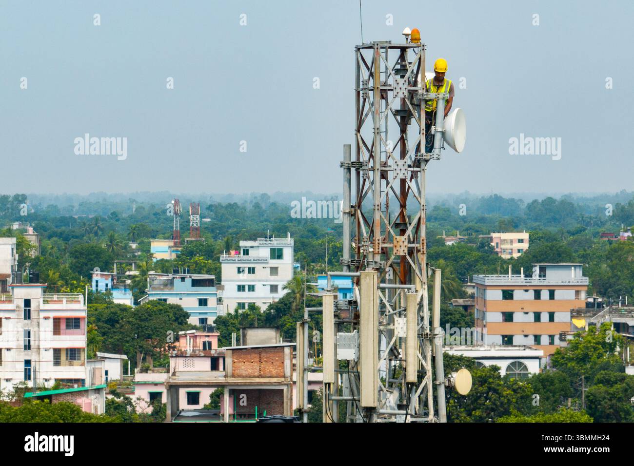 Techniker klettern über den Netzwerkturm mit Sicherheitsausrüstung, Beheben von Problemen mit dem Mobilfunkturm, Hochhaus-Mobilfunkturm, Funkantenne, drahtloses Netzwerk Stockfoto