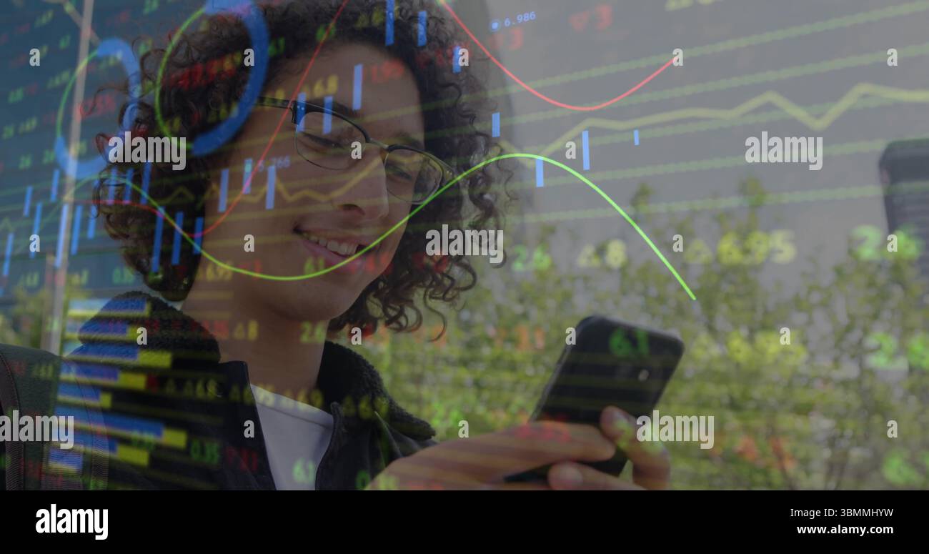 Ein lächelnder Mann mit Brille und Jacke, der auf der Außenterrasse das Telefon überprüft, mit Aktienkarten Stockfoto