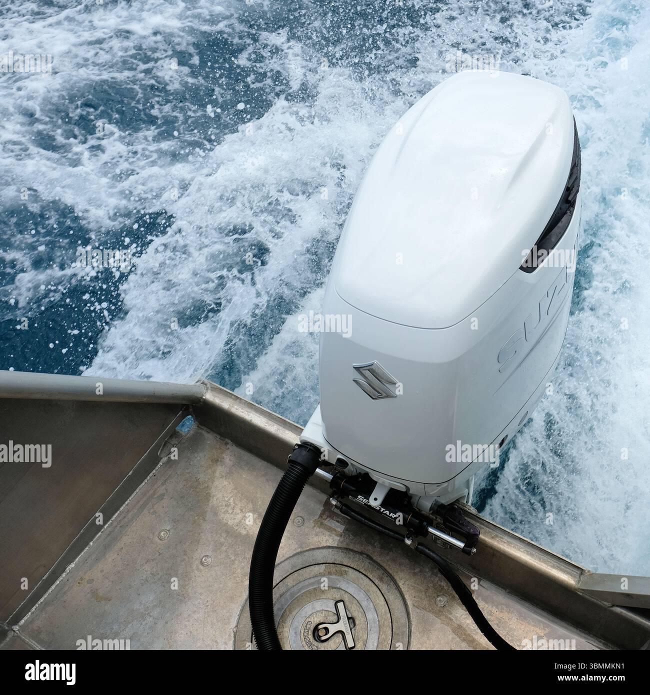 Suzuki 300 PS V6 Viertakt-Außenbordmotor, montiert auf einem Seefahrer-Wasserfahrzeug, das ein Boot mit Schaum und Wake im Wasser antreibt; weißer Antriebskopf. Stockfoto