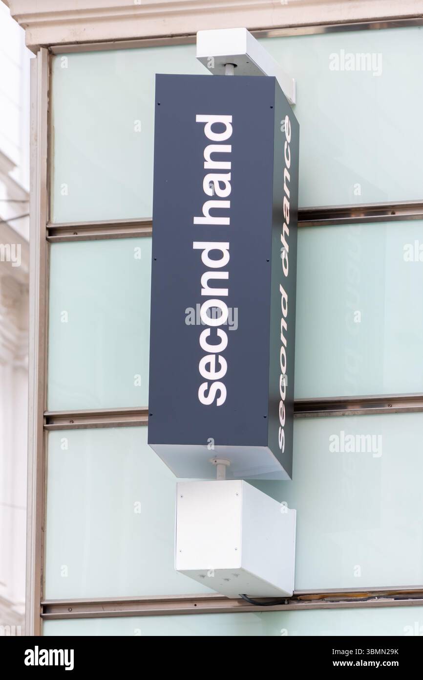 Ein Ladenschild aus gebrauchter Hand mit den Worten „Second Hand“ und „Second Chance“ an der Fassade eines modernen Gebäudes, Österreich, Wien, 27. Juni 2025. Stockfoto