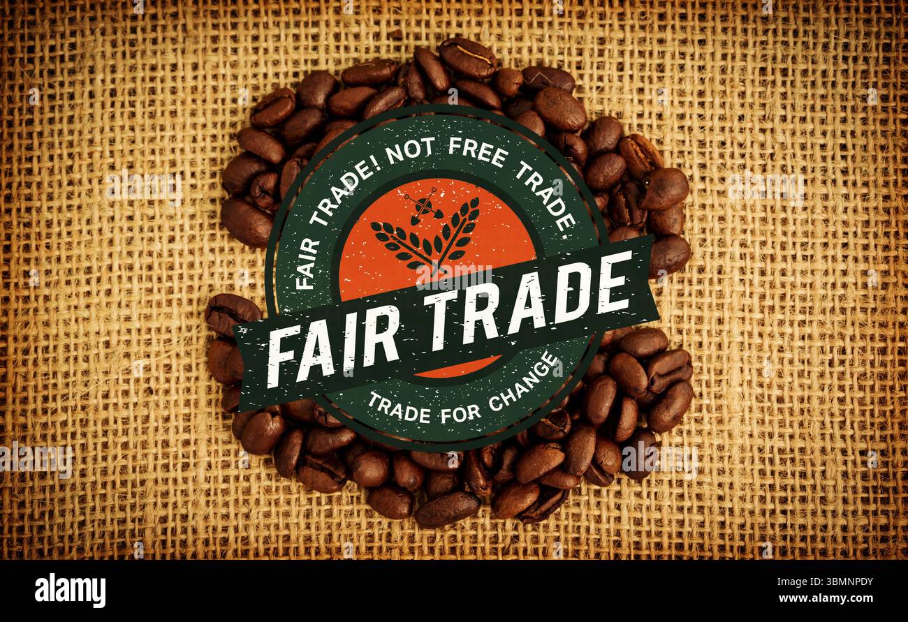Das kreisförmige Fair Trade-Emblem liegt in flacher Form auf einer Oberfläche mit Sackleinen, umgeben von Kaffeebohnen Stockfoto