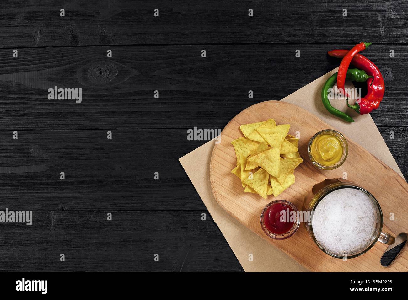 Glas Bier mit Nachos-Chips auf Holzhintergrund. Draufsicht. Speicherplatz kopieren. Stillleben. Flach liegend Stockfoto