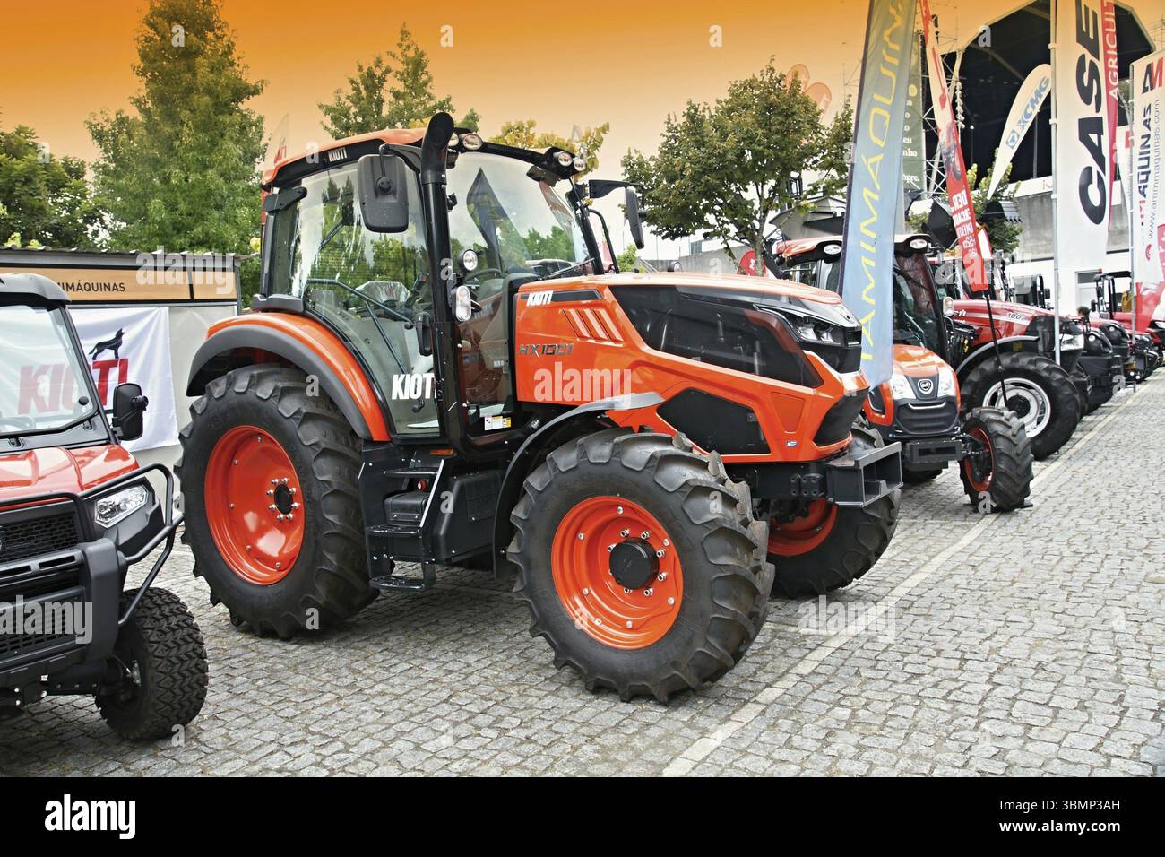 Der moderne Kioti HX100-Traktor parkte neben anderen landwirtschaftlichen Fahrzeugen auf der Maschinenmesse und stellte die neueste Landtechnik vor Stockfoto
