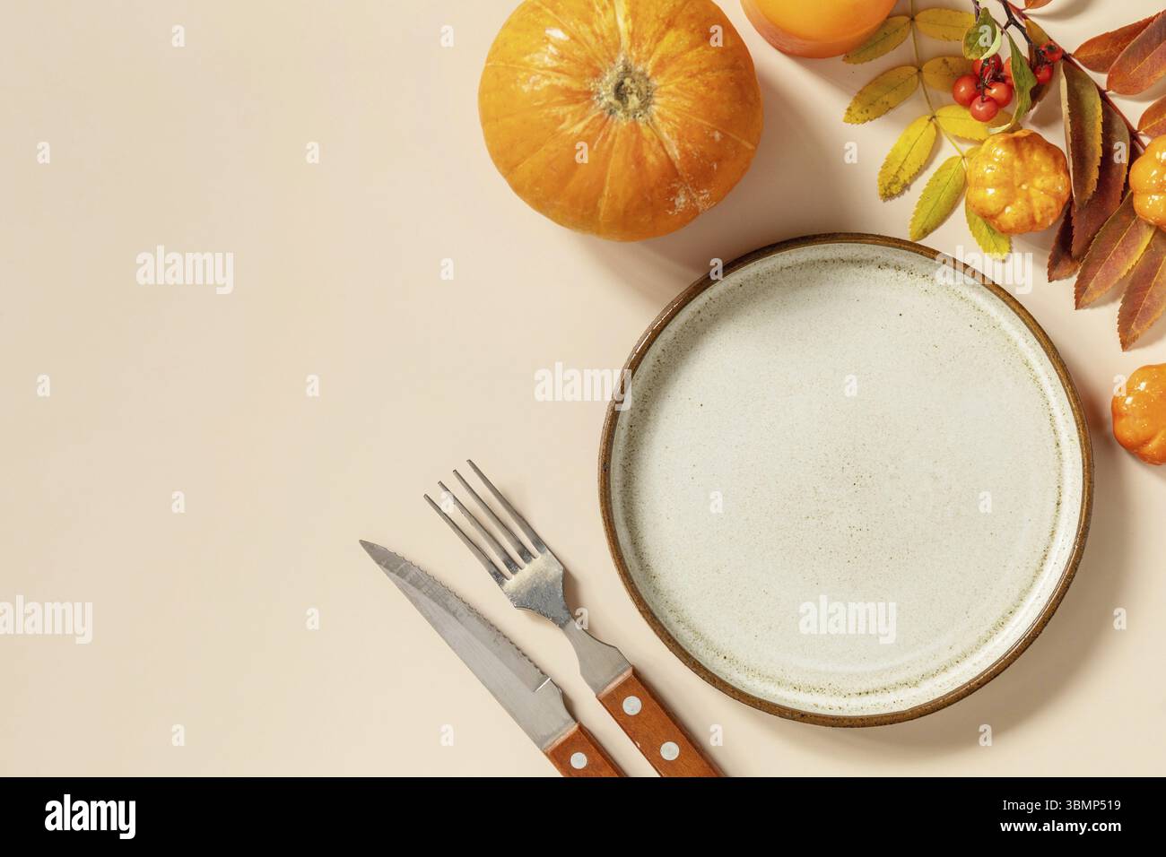 Herbst Halloween oder Thanksgiving Tagestisch Einstellung. Herbsthintergrund mit leerem Teller, Besteck, Kürbissen. Thanksgiving Hintergrund Nachbildung. Ansicht fr Stockfoto