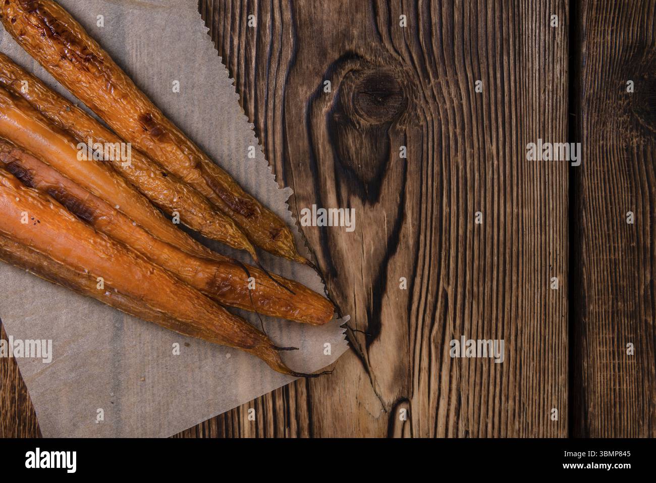 Portion gebackene Karotten (Nahaufnahme) auf einem alten Vintage-Hintergrund Stockfoto