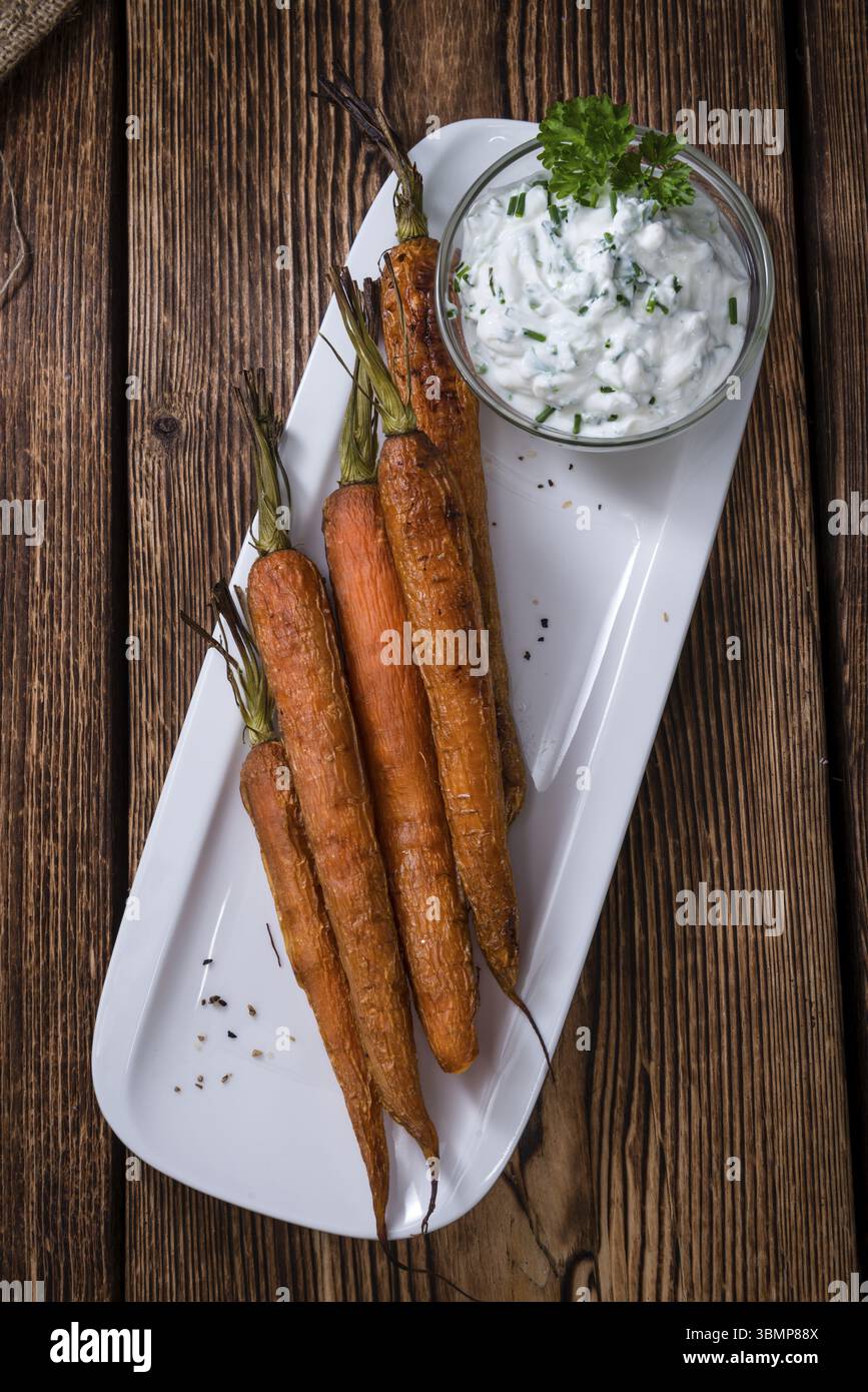 Portion gebackene Karotten (Nahaufnahme) auf einem alten Vintage-Hintergrund Stockfoto