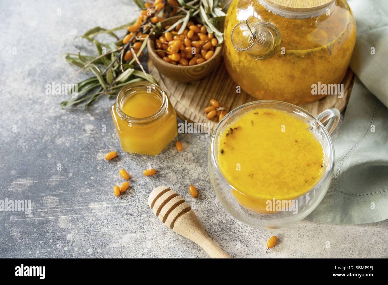 Meer â€‹ â€‹ â€‹ â€‹ Sanddorn und Tasse gesundes Meer â€‹ â€‹ â€‹ â€‹€‹Sanddorntee mit Honig auf einem Steintisch. Herbsttee, Beeren, saisonales Getränk. Kopierbereich Stockfoto