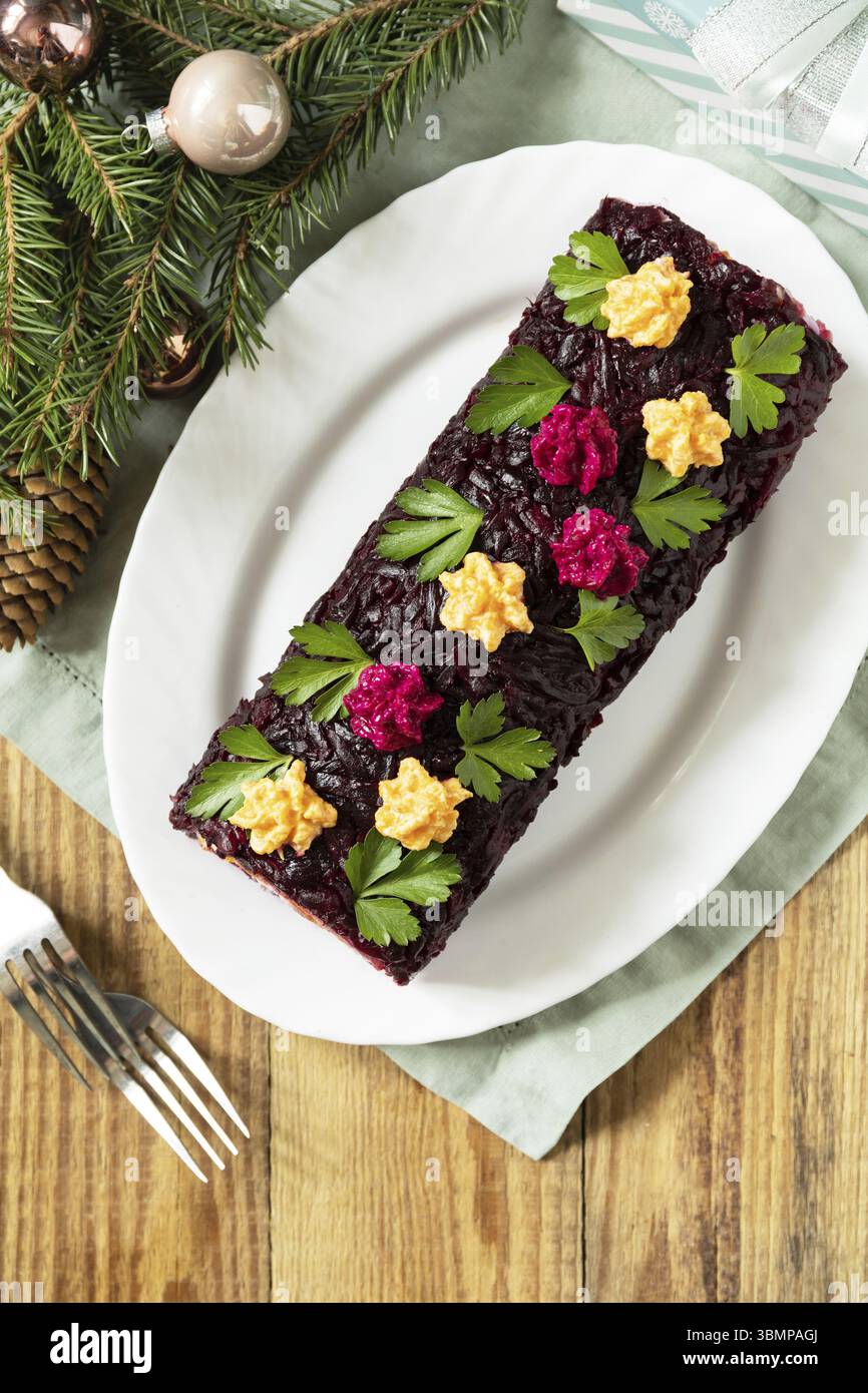 Weihnachts-Vorspeise Neujahrsmahlsidee. Festlicher Salat in Lagen. Weihnachten Neujahr Gemüsesalat mit Hering und gekochtem Gemüse. Ansicht von einem Stockfoto
