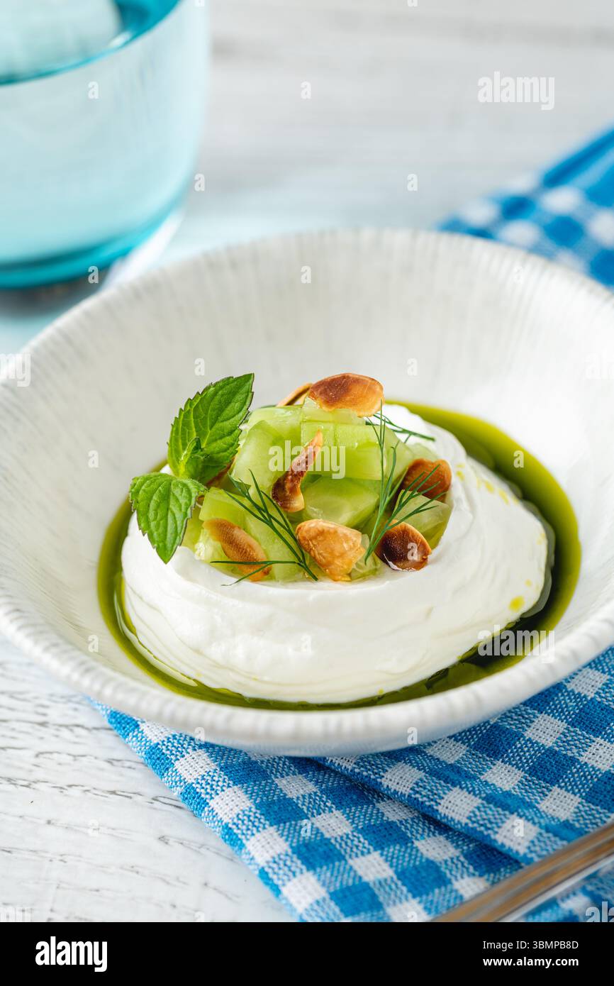 Cremiger Joghurt mit gerösteten Nüssen und Kräuteröl-Wirbel Stockfoto