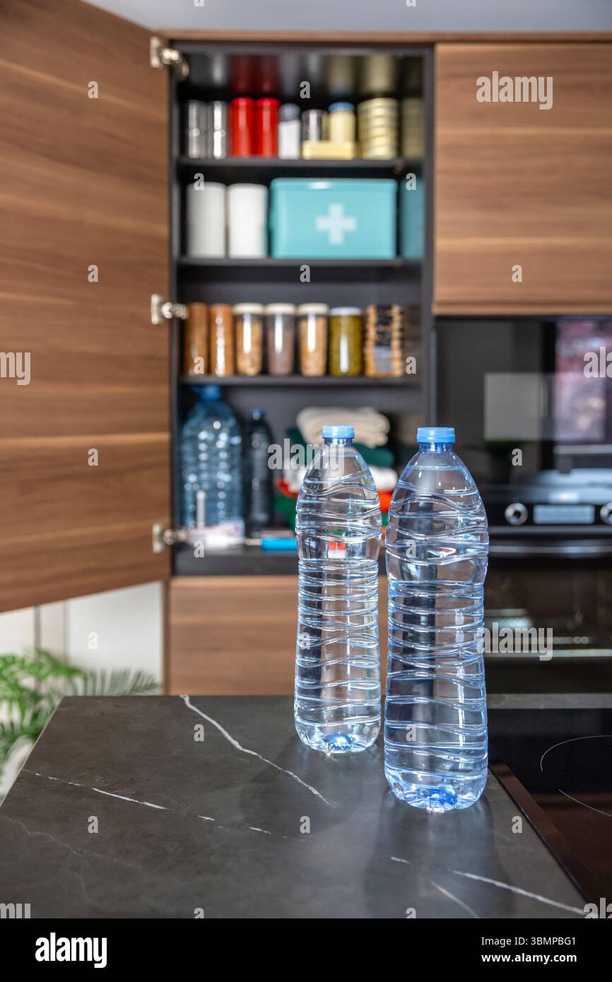 Wasserflaschen als Teil des 72 Hour Survival Kit. Notfallpantry mit Essen, Getränk und erste-Hilfe-Set. Stockfoto