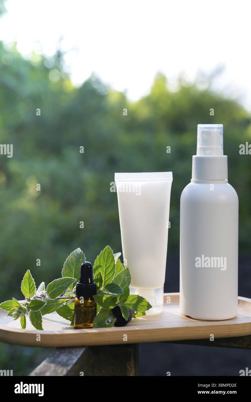 Weiße handgemachte Kosmetikflaschen Vorlage Mockup Hautpflege Kräuter Alternative Insektenschutz draußen im Sommer. Ich versuche, Mücken zu töten Stockfoto