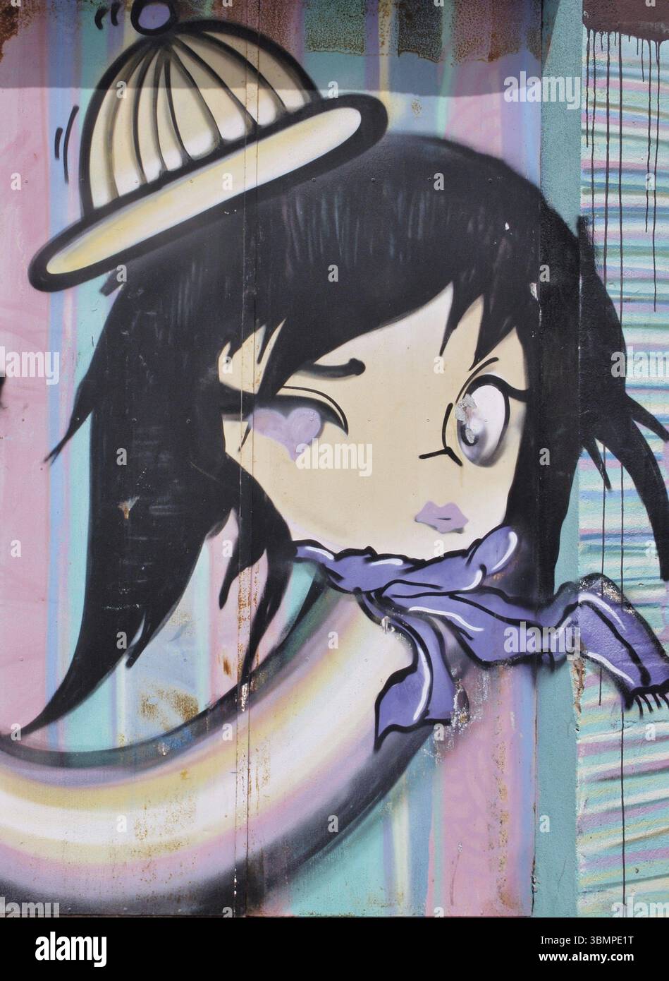 Graffiti-Kunst, die ein blinkendes Cartoon-Mädchen mit gelber Beanie-Mütze und lila Schal auf einer farbenfrohen Wand darstellt Stockfoto