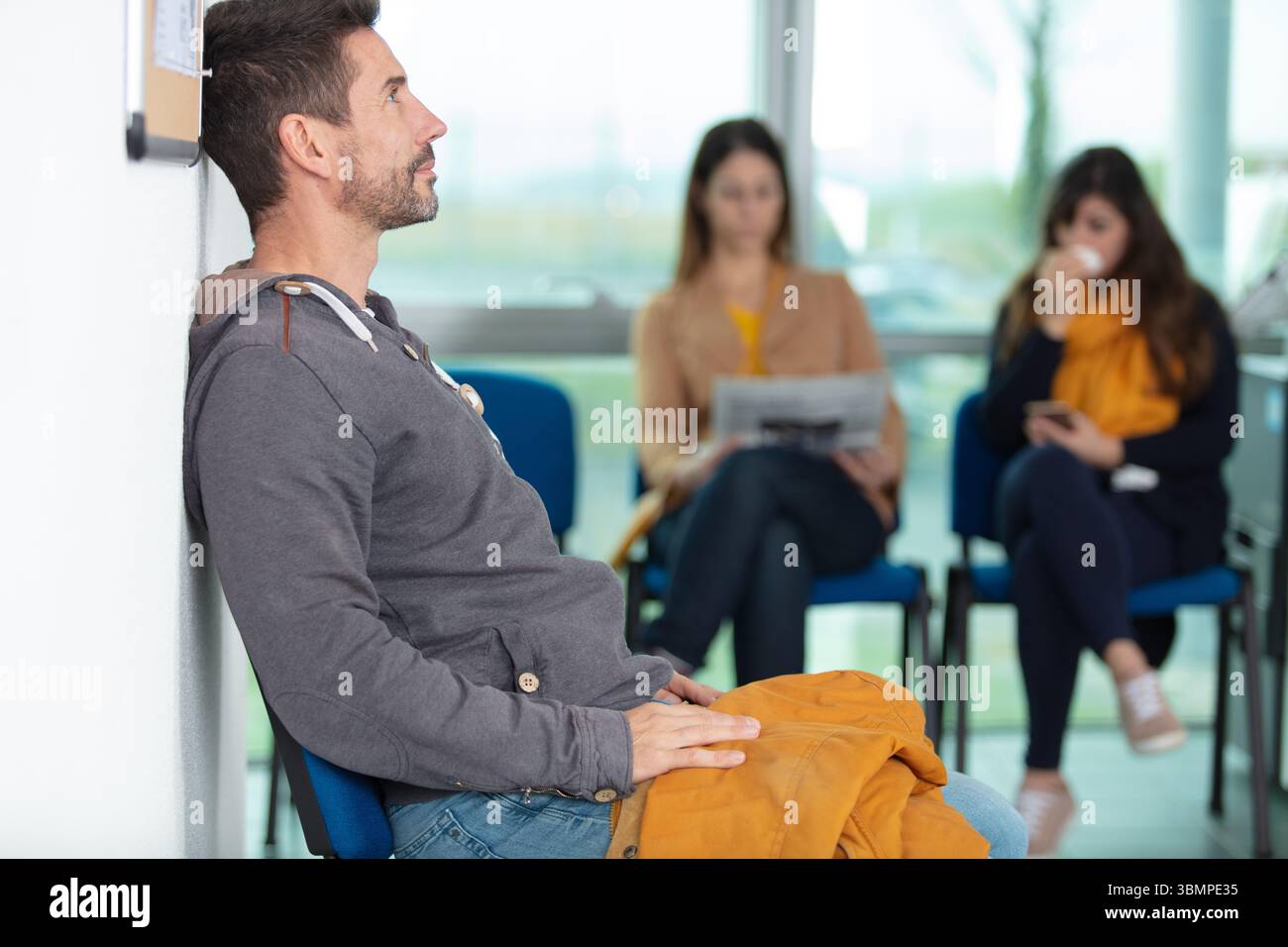 Verschiedene Leute sitzen im Wartezimmer Stockfoto