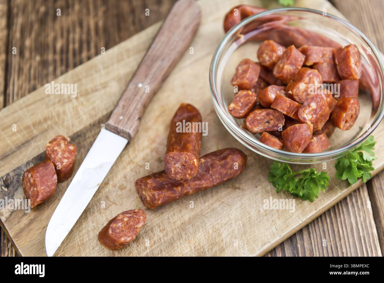 Deutsche Mettwurst (Chili aromatisiert) als Nahaufnahme (Tiefenschärfe) auf hölzernen Hintergrund Stockfoto