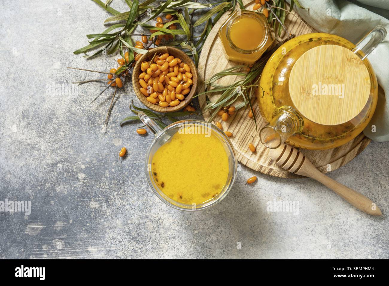 Meer â€‹ â€‹ â€‹ â€‹ Sanddorn und Tasse gesundes Meer â€‹ â€‹ â€‹ â€‹€‹Sanddorntee mit Honig auf einem Steintisch. Herbsttee, Beeren, saisonales Getränk. Ansicht von Stockfoto