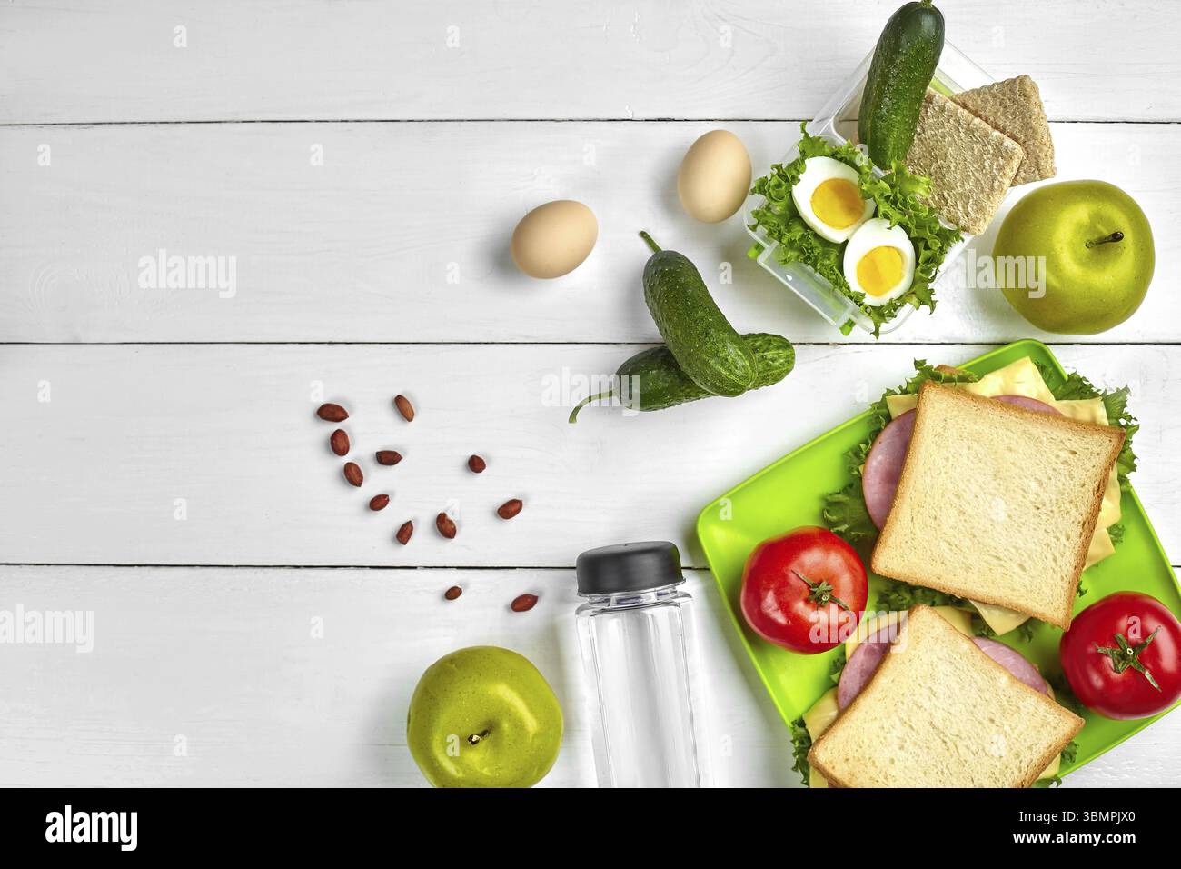Mittagessen. Sandwich und frisches Gemüse, eine Flasche Wasser, Nüssen und Früchten auf weißem Holz- Hintergrund. Gesunde Ernährung Konzept. Ansicht von oben mit der Kopie. S Stockfoto