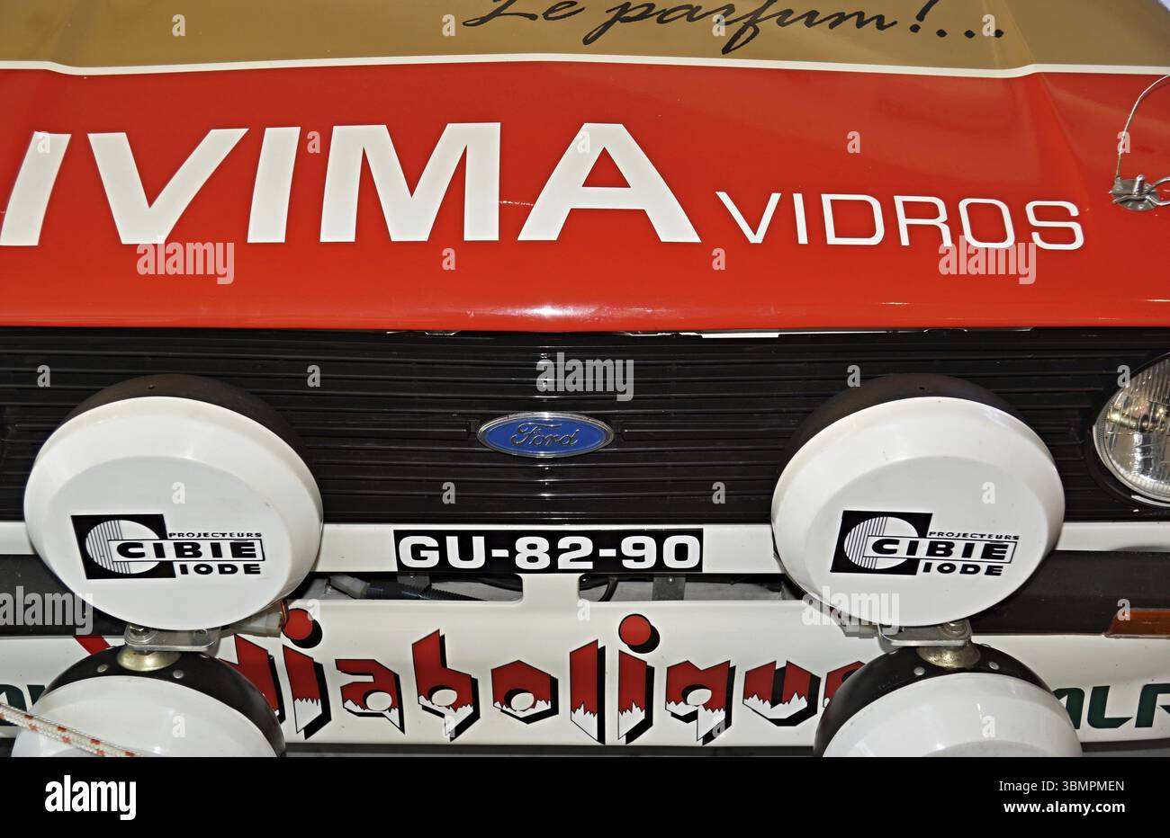 Nahaufnahme eines Ford Escort RS2000 Rallyefahrzeugs, das verschiedene Sponsoren und Cibie-Spots hervorhebt und ein Gefühl für Motorsport-Tradition weckt Stockfoto