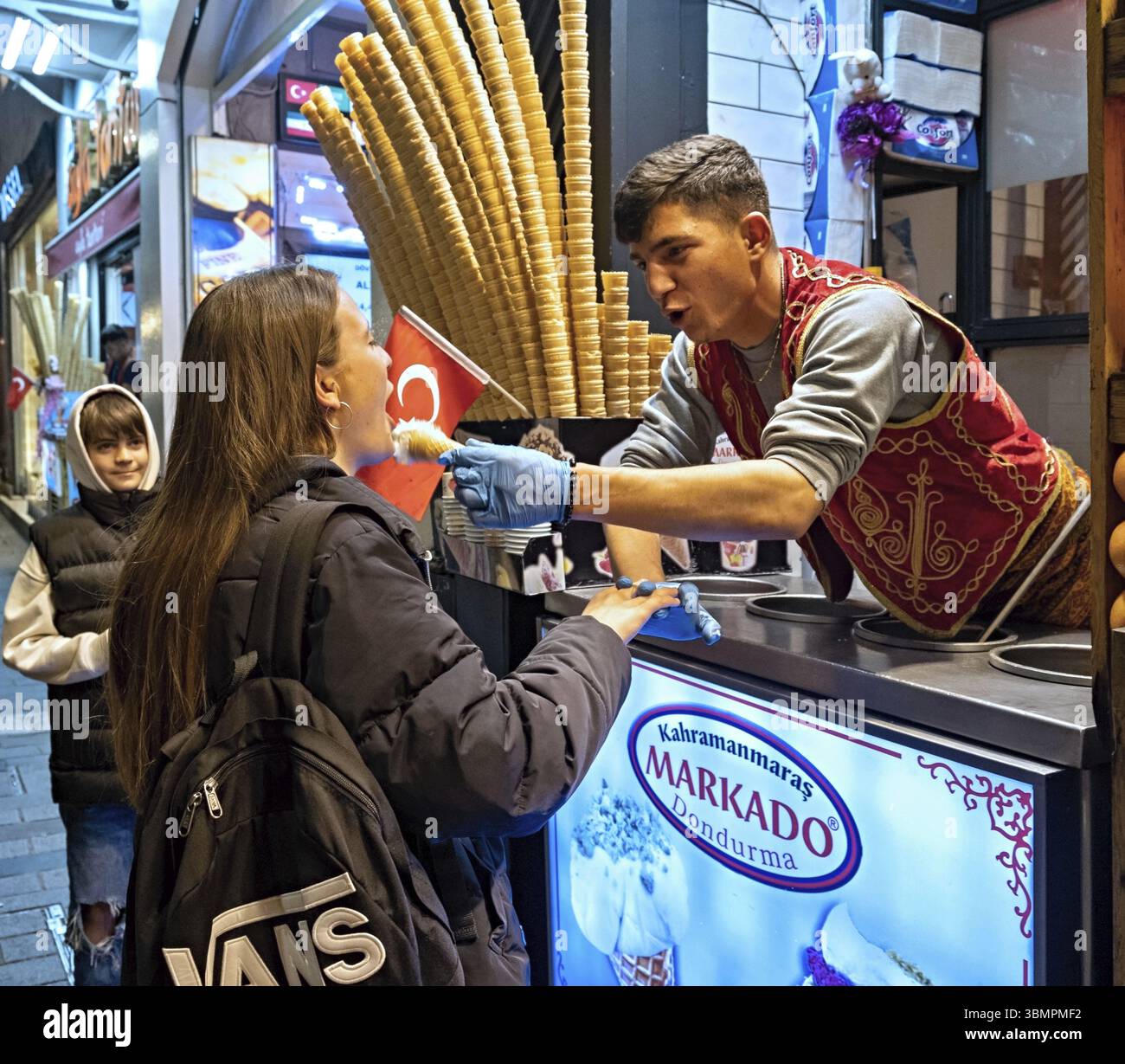 Straßenverkäufer serviert traditionelles türkisches Eis namens Dondurma für junge Frau in Istanbul Stockfoto