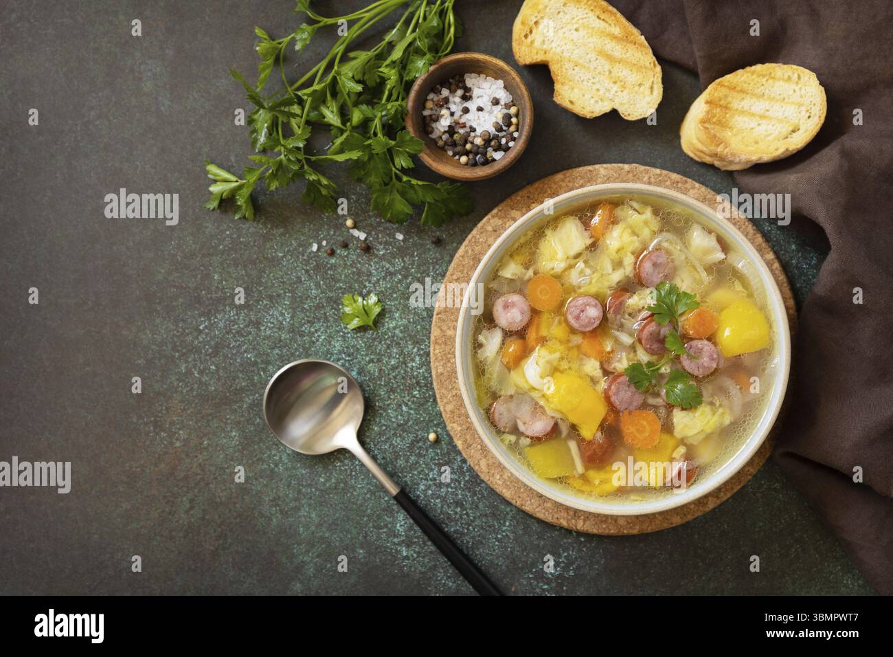 Traditionelle Zelnacka-Kohl-Suppe mit Würstchen und Gemüse in einer Schüssel auf einer Steinplatte. Tschechische Küche. Blick von oben. Kopierbereich Stockfoto