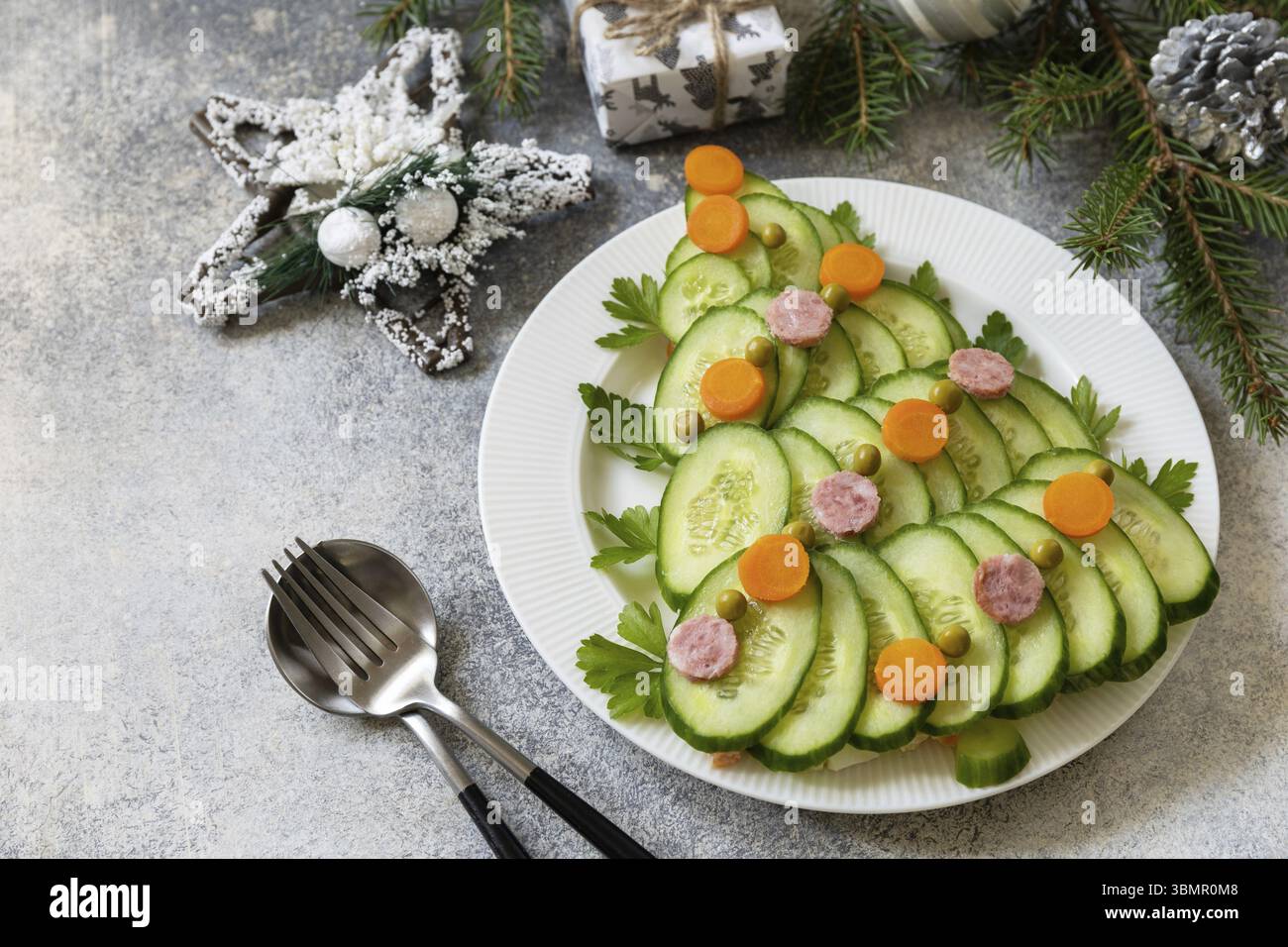 Weihnachtsbaum aus einem Salat olivier auf grauem Steinhintergrund. Vorspeise zu Weihnachten. Kopierbereich Stockfoto
