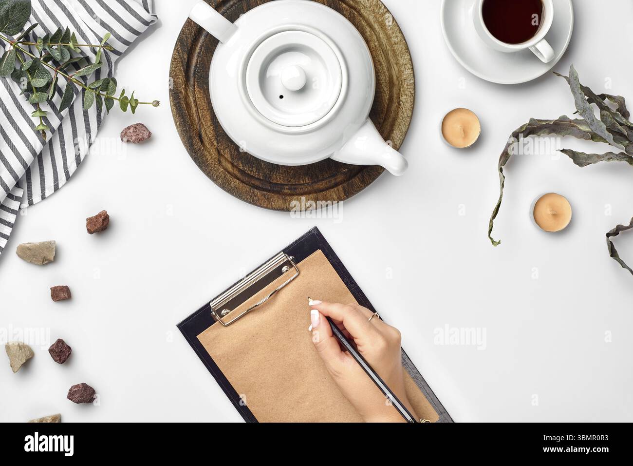 Eine Frau Hände schreiben auf leeres Buch Hinweis, Tagebuch, Verbreitung Mockup, Ansicht von oben, Studio. Tasse Kaffee Pause. Der leere Raum im Notebook für Blog Einträge können Sie c Stockfoto