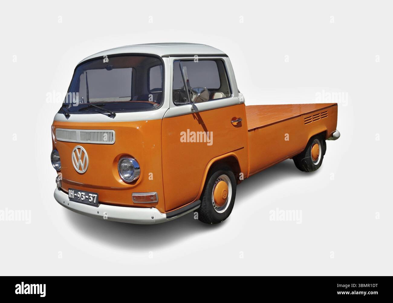 Restaurierter Volkswagen T1 Pickup mit Einzelkabine in Orange und weiß, auf weißem Hintergrund geparkt Stockfoto