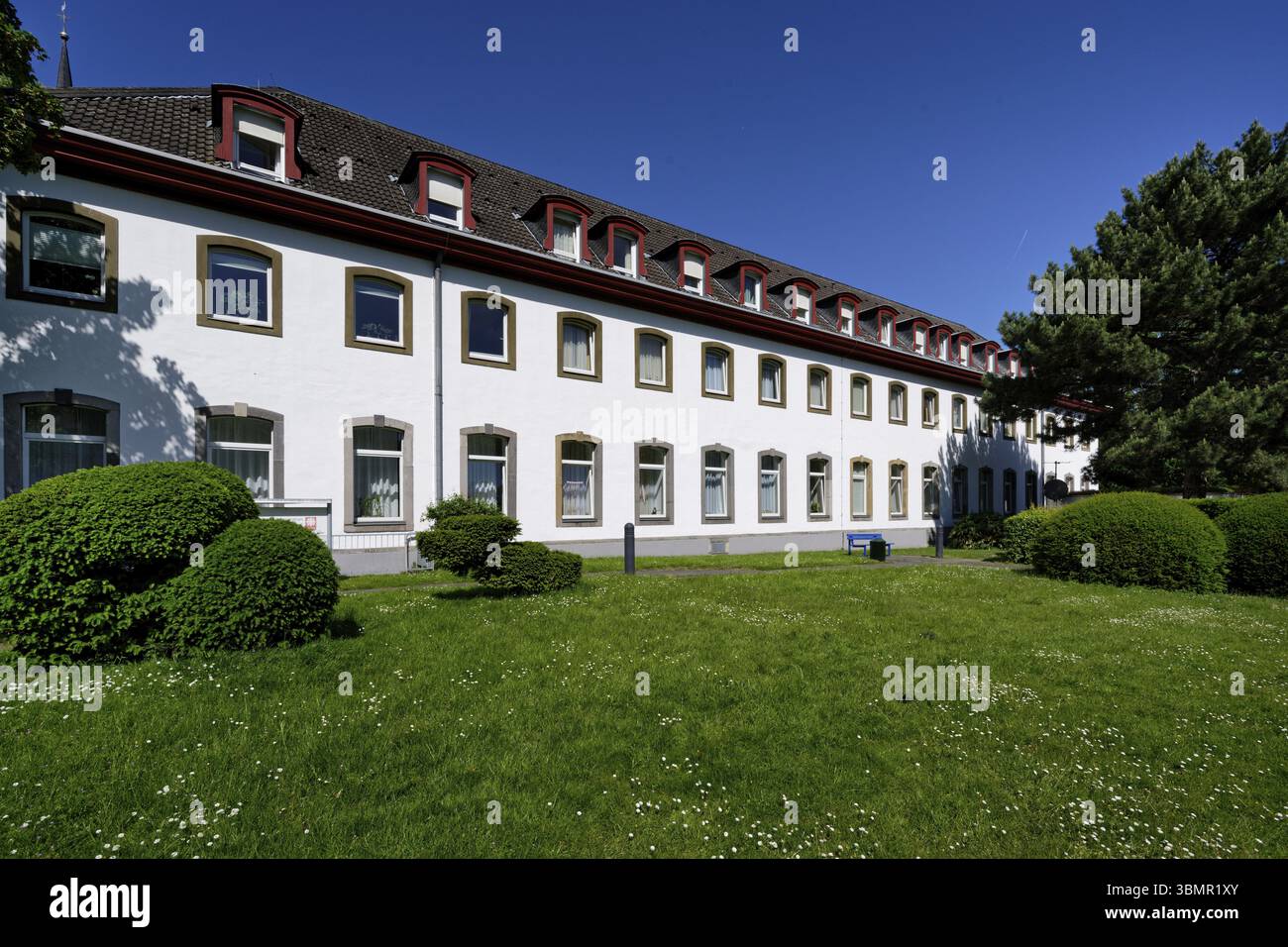 Haus der St. heribert Altenheim der caritas in köln deutz vor einer blühenden Frühlingswiese Stockfoto