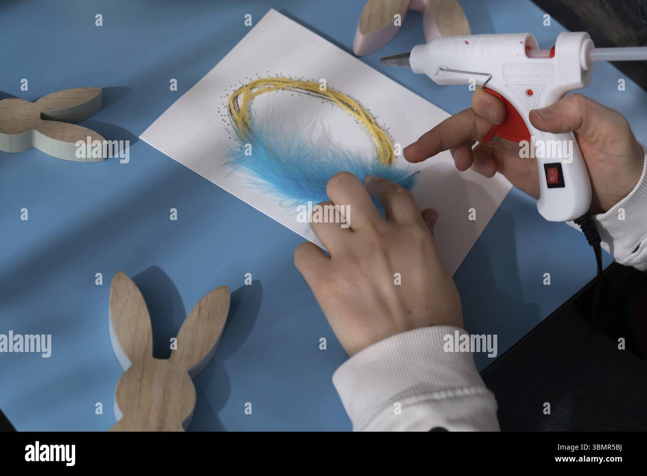 Osterei aus Baumwollseil und Feder machen Geschenk Osteridee. Machen Sie es selbst Anleitung Postkarte umweltfreundliche Dekoration. Handgemachte Kunst, Präsente Stockfoto