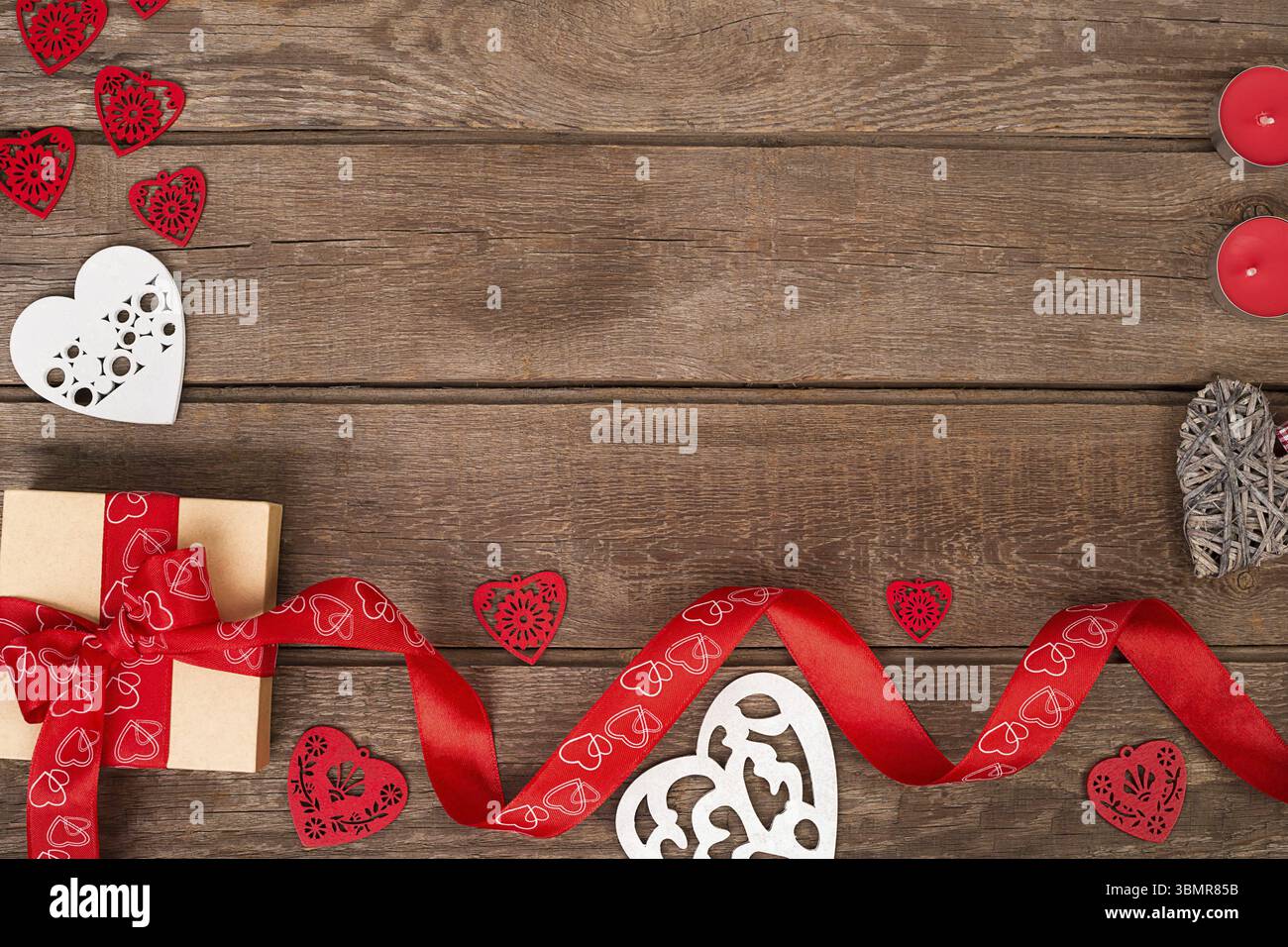 Geschenkbox und rotes Band mit Anhänger auf Holzhintergrund mit Platz. Stillleben Stockfoto