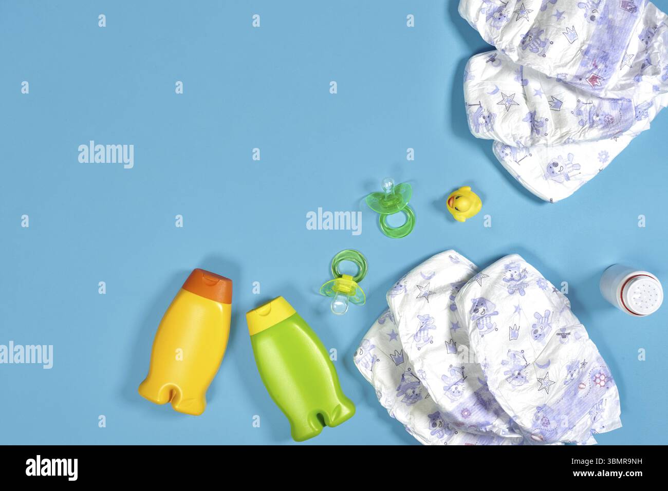 Babypflege mit Badeset. Nippel, Spielzeug, Windeln, Shampoo auf blauem Hintergrund Draufsicht. Flache Lagen. Stillleben. Kopierbereich Stockfoto