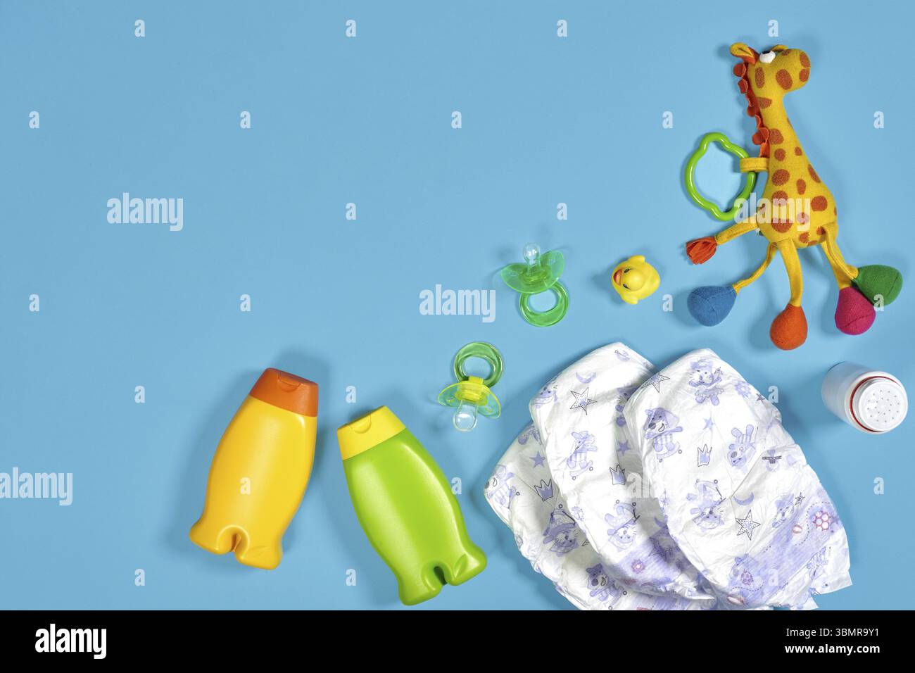 Babypflege mit Badeset. Nippel, Spielzeug, Windeln, Shampoo auf blauem Hintergrund Draufsicht. Flache Lagen. Stillleben. Kopierbereich Stockfoto