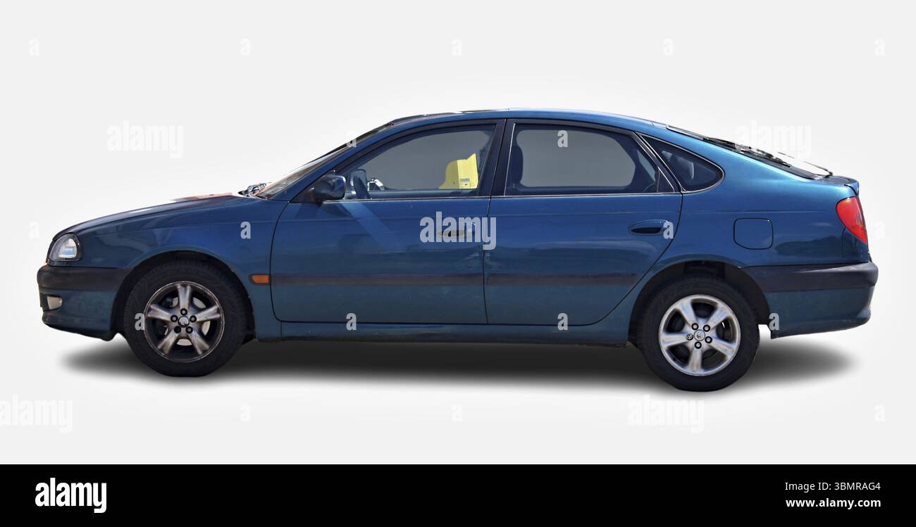 Klassischer Toyota Avensis mit leicht abgenutzter Farbe, geparkt, zeigt die linke Seite, isoliert auf weißem Hintergrund Stockfoto
