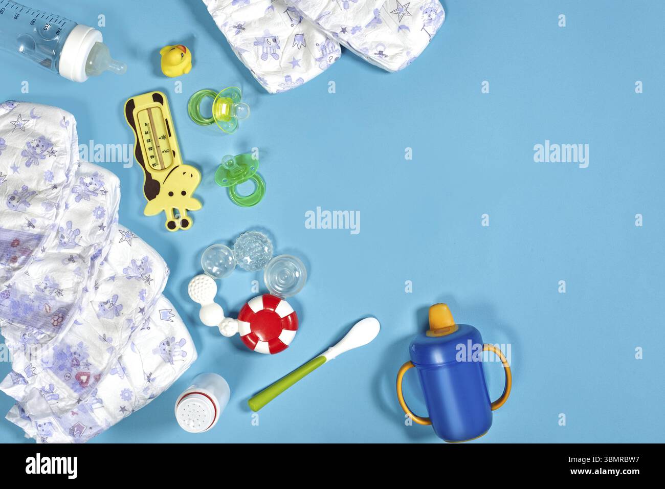 Babywaren: Stoffwindel, Babypuder, Knabber, Creme, Beißring, Schnuller, Babyspielzeug auf blauem Hintergrund. Kopierbereich. Draufsicht. Frühkindliche Entwicklung Stockfoto