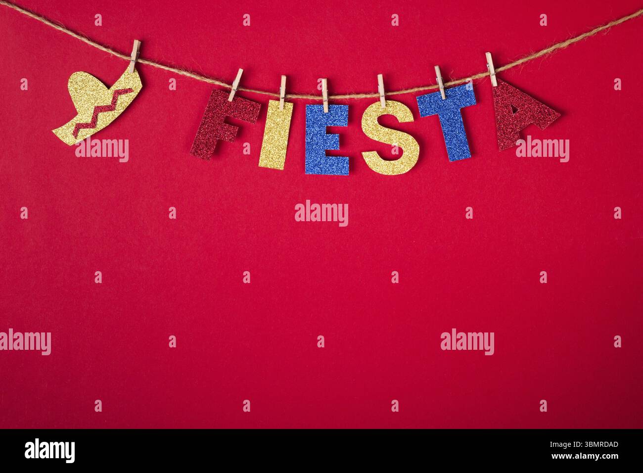 Fiesta Word und Sombrero auf Pinseln aus glänzendem Papier auf rotem Hintergrund. Cinco de Mayo Konzept Stockfoto