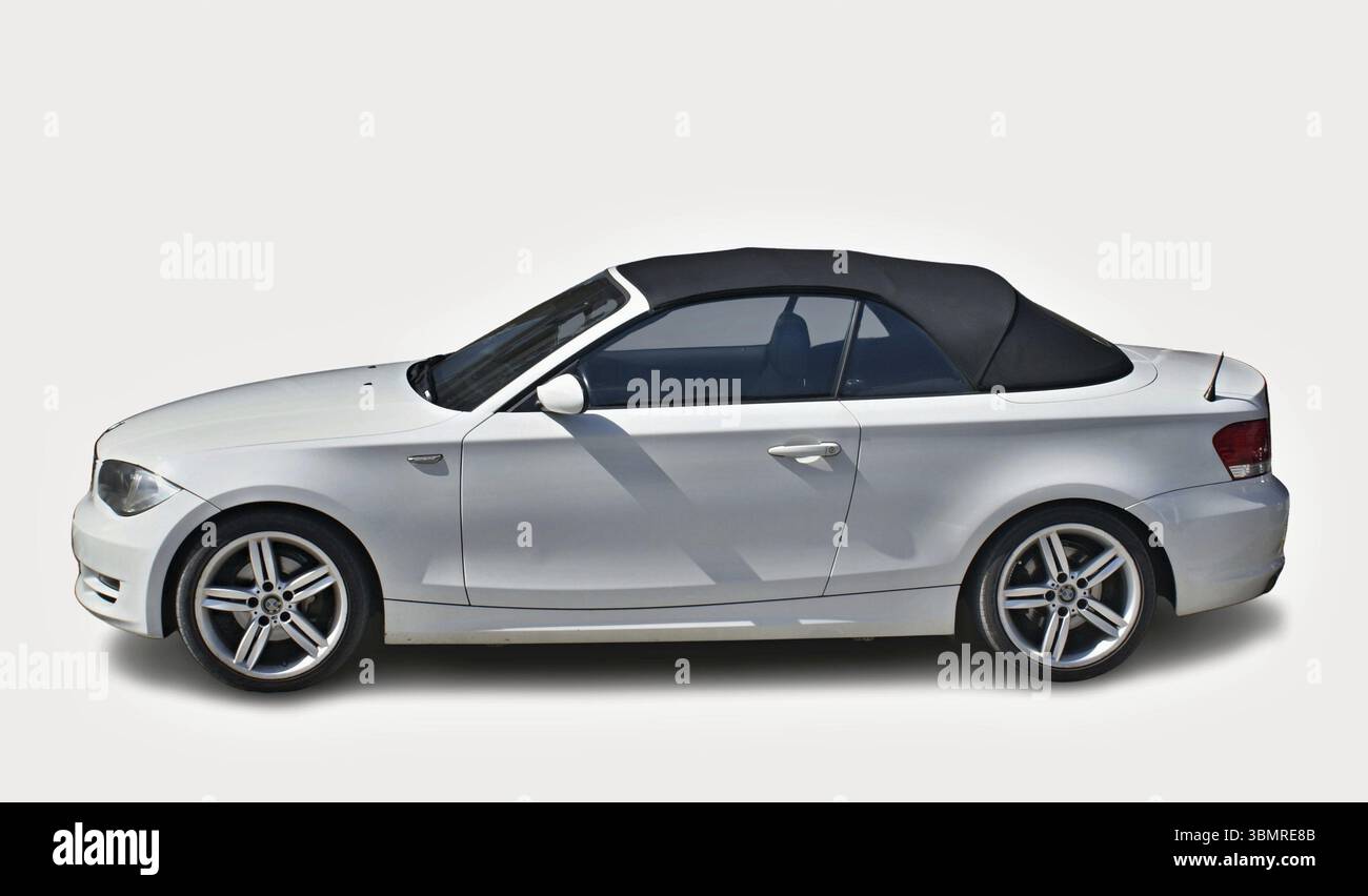 Elegantes weißes BMW 1er Cabriolet mit schwarzem Faltverdeck auf weißem Hintergrund und elegantem Design Stockfoto