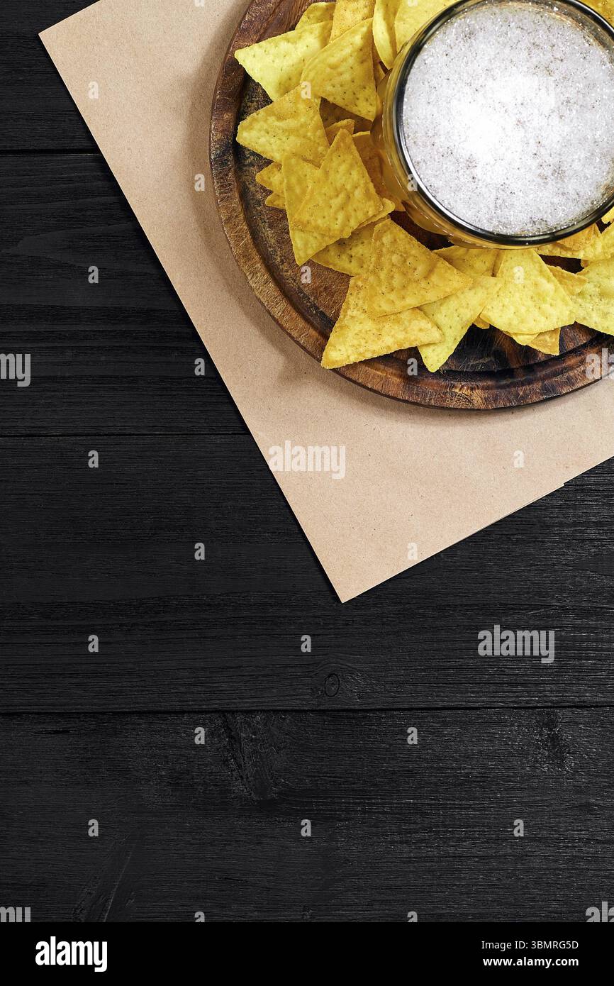 Glas Bier mit Nachos-Chips auf Holzhintergrund. Draufsicht. Speicherplatz kopieren. Stillleben. Flach liegend Stockfoto