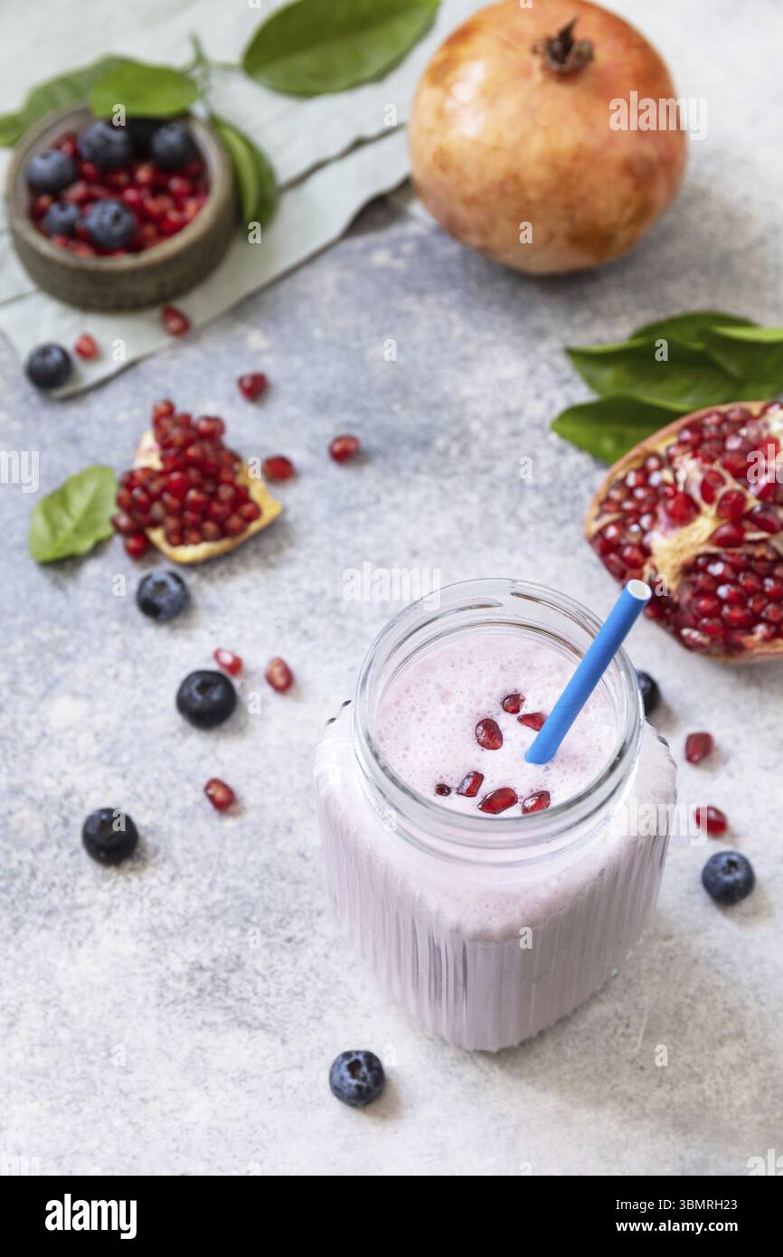 Veganer Protein-Smoothie aus Granatapfel und Heidelbeere auf einer Steinplatte. Gesunde Ernährung. Lifestyle Wellness. Foodismus, Rawism, Rohkost-Diät Stockfoto