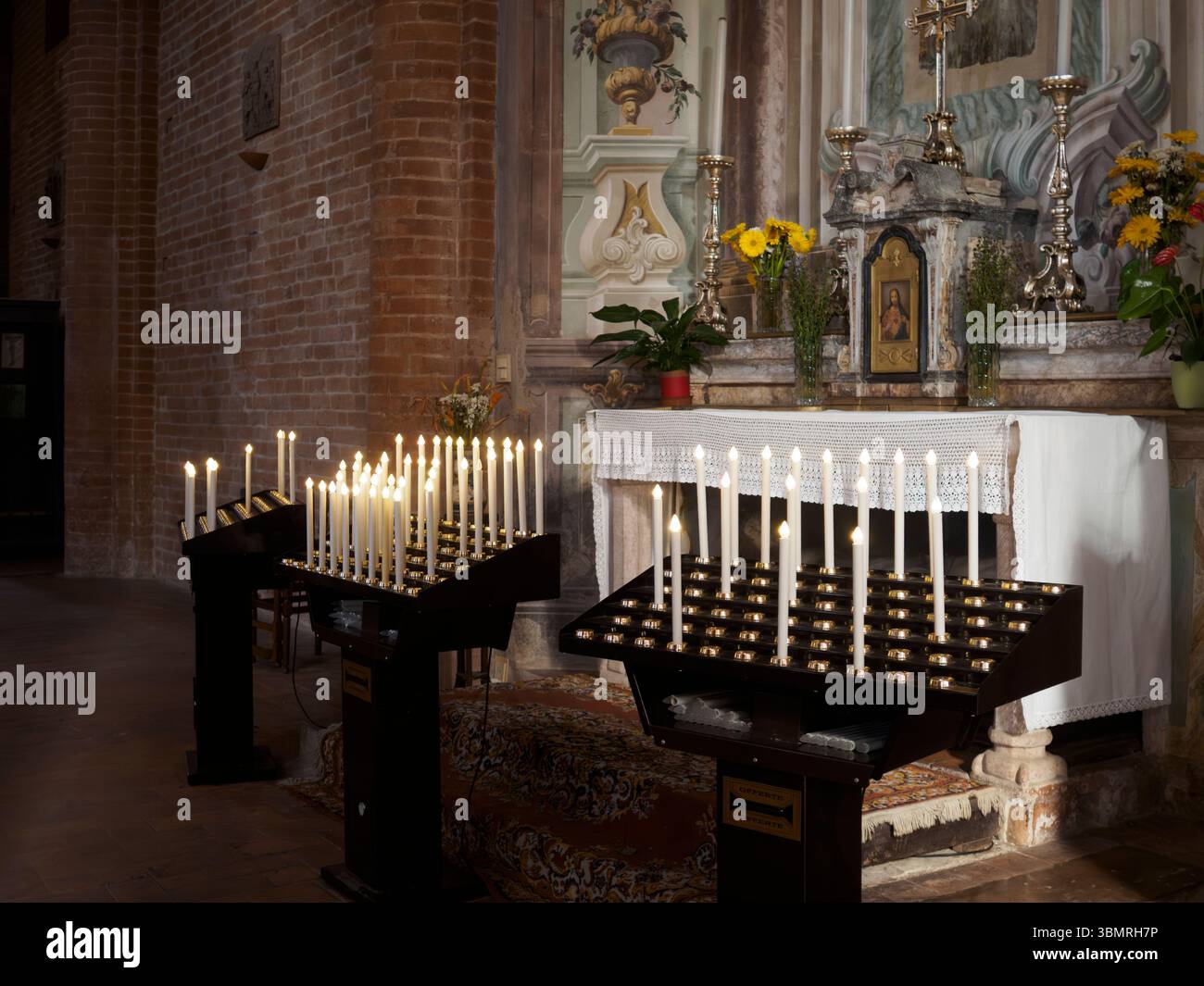 Alseno, Italien 22. Juni 2025 viele elektrische Kerzen brennen auf speziellen Stützen vor dem Altar der Zisterzienserabtei von Chiaravalle della Stockfoto