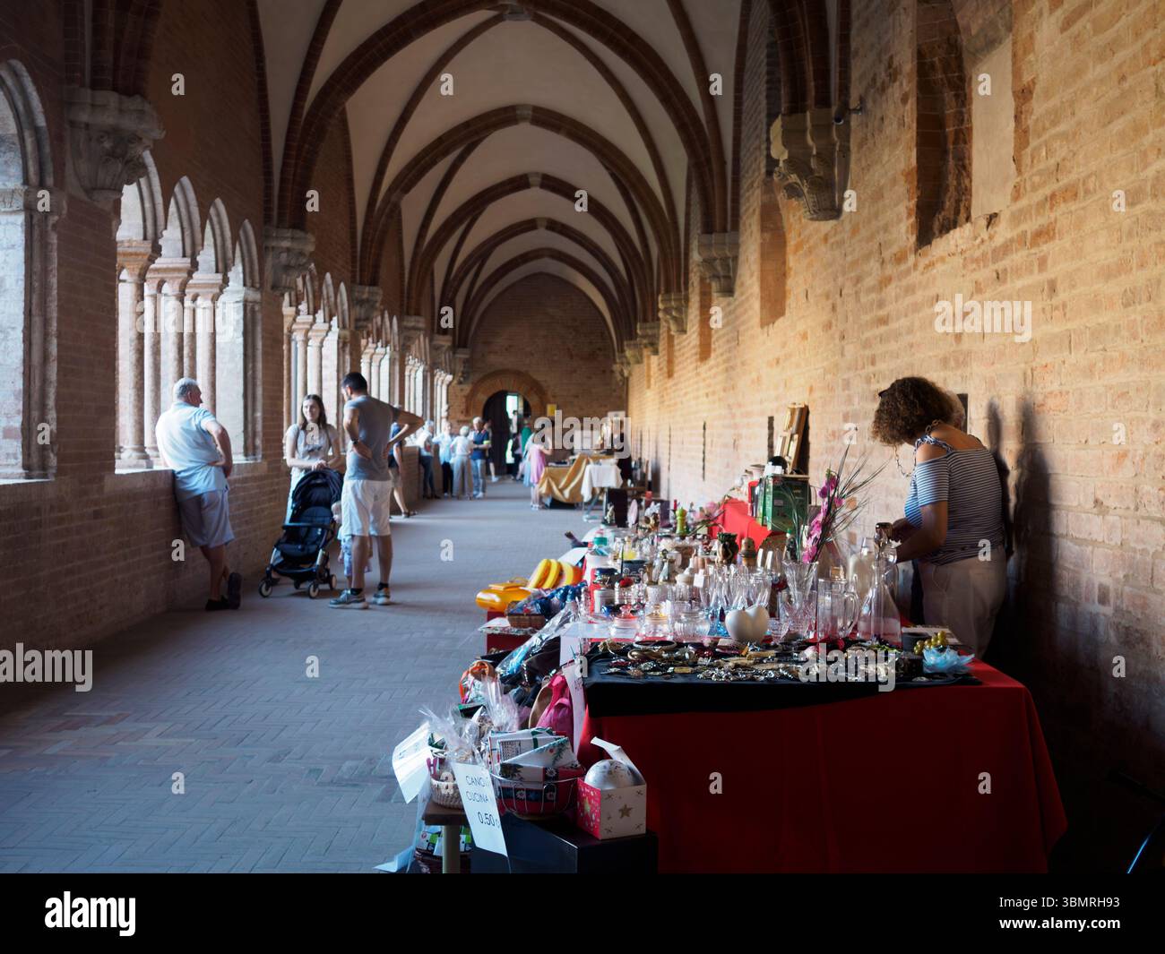 Alseno, Italien 22. Juni 2025 Touristen und Händler gehen und verkaufen Gegenstände im suggestiven Kreuzgang der Abtei Chiaravalle della Colomba Stockfoto