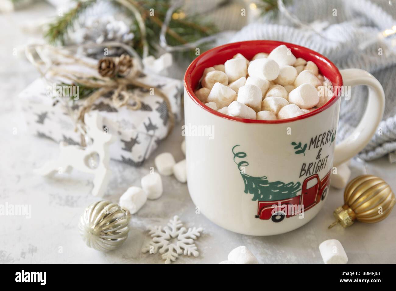 Weihnachten Winter Gemütliches Tasse heiße Schokolade Getränk mit Marschall und Geschenke, weihnachtslichter, Pullover gestrickt auf einem grauen Stein Hintergrund. Weihnachtliche Swee Stockfoto