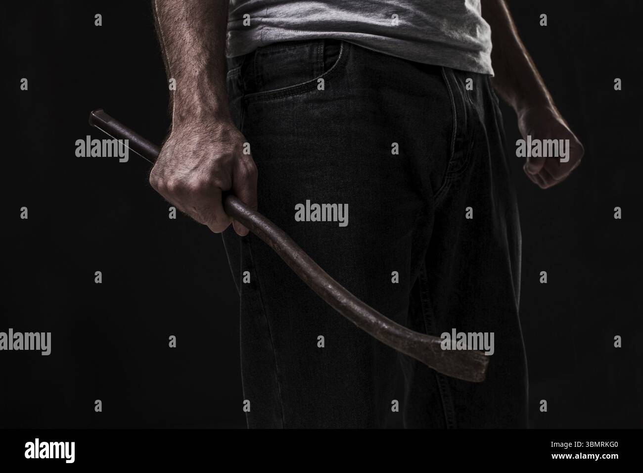 Männlicher Täter mit einem Schrott. Auf schwarzem Hintergrund im Studio. Zerbrechen. Ein Verbrechen. Bandit und Dieb Stockfoto