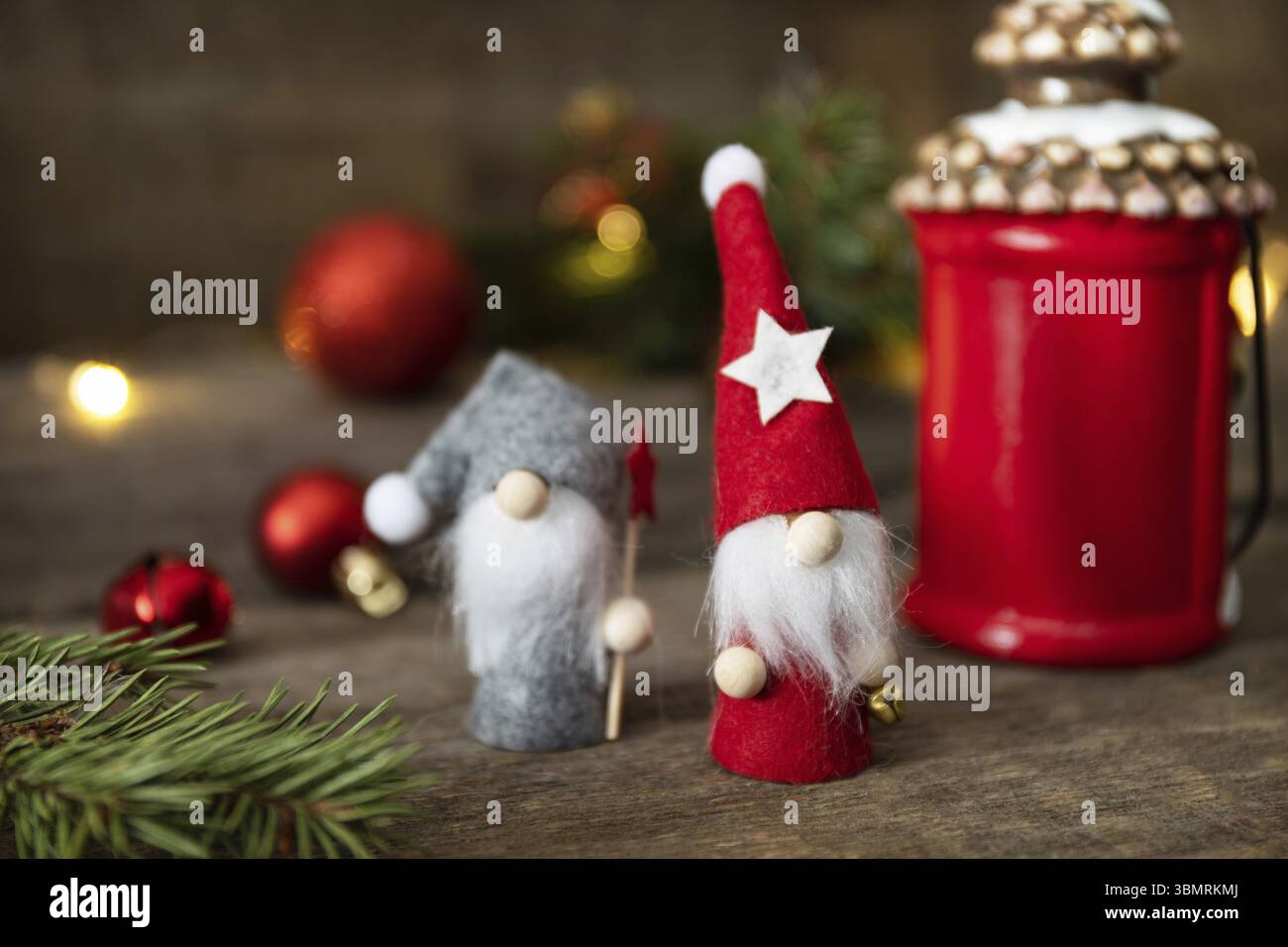 Weihnachtskonzept. Weihnachtskarte mit Gnomen, Tanne, weihnachtsbeleuchtung und Dekor auf rustikalem Holzhintergrund Stockfoto