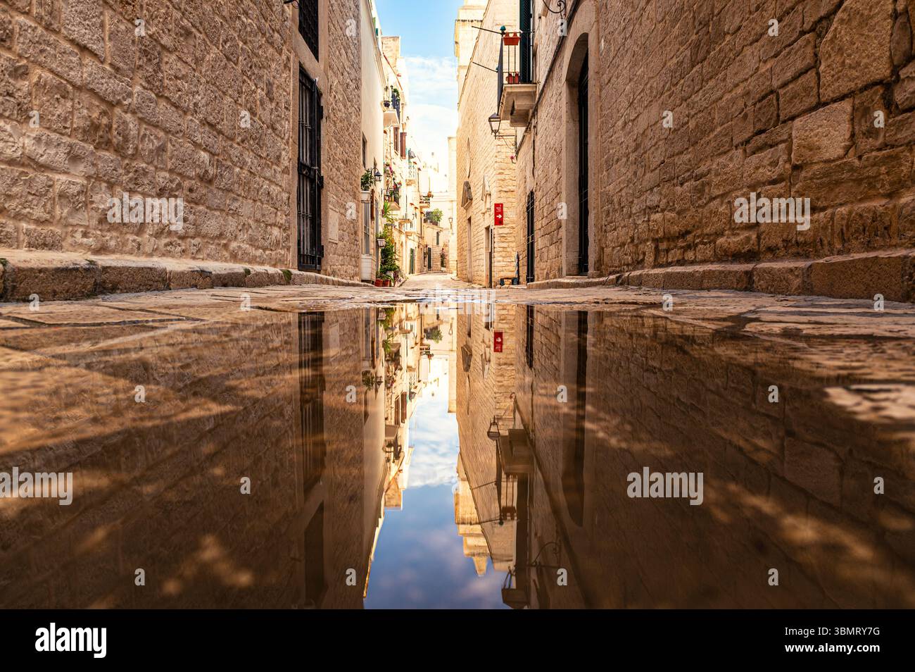 Enge Straße von Trani, Italien, mit einer Reflexion auf dem Wasser Stockfoto