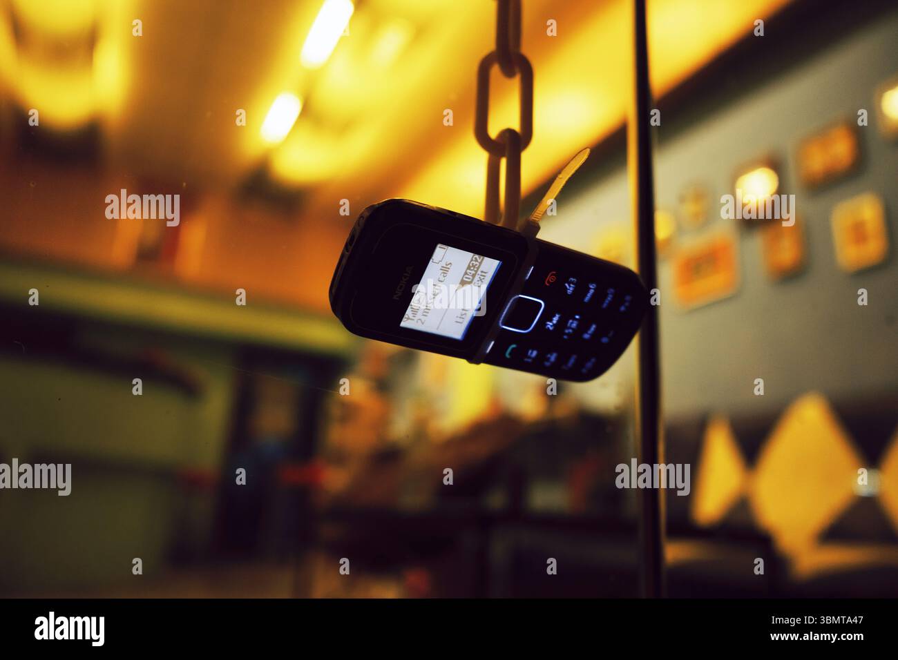 Hängendes Nokia-Feature-Telefon Zeigt Entgangene Anrufe An, Warmes Bokeh-Interieur Stockfoto