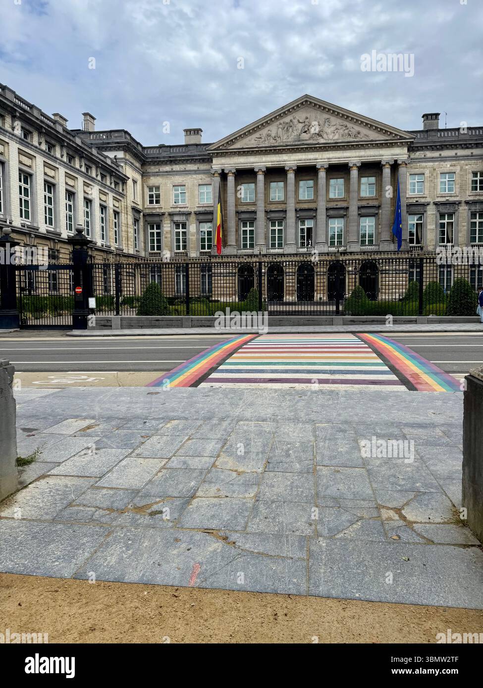 Vorderansicht des belgischen Bundestagsgebäudes in Brüssel mit einem regenbogenbemalten Quersteg, der den Stolz und die Inklusivität von LGBTQ+ symbolisiert. Stockfoto